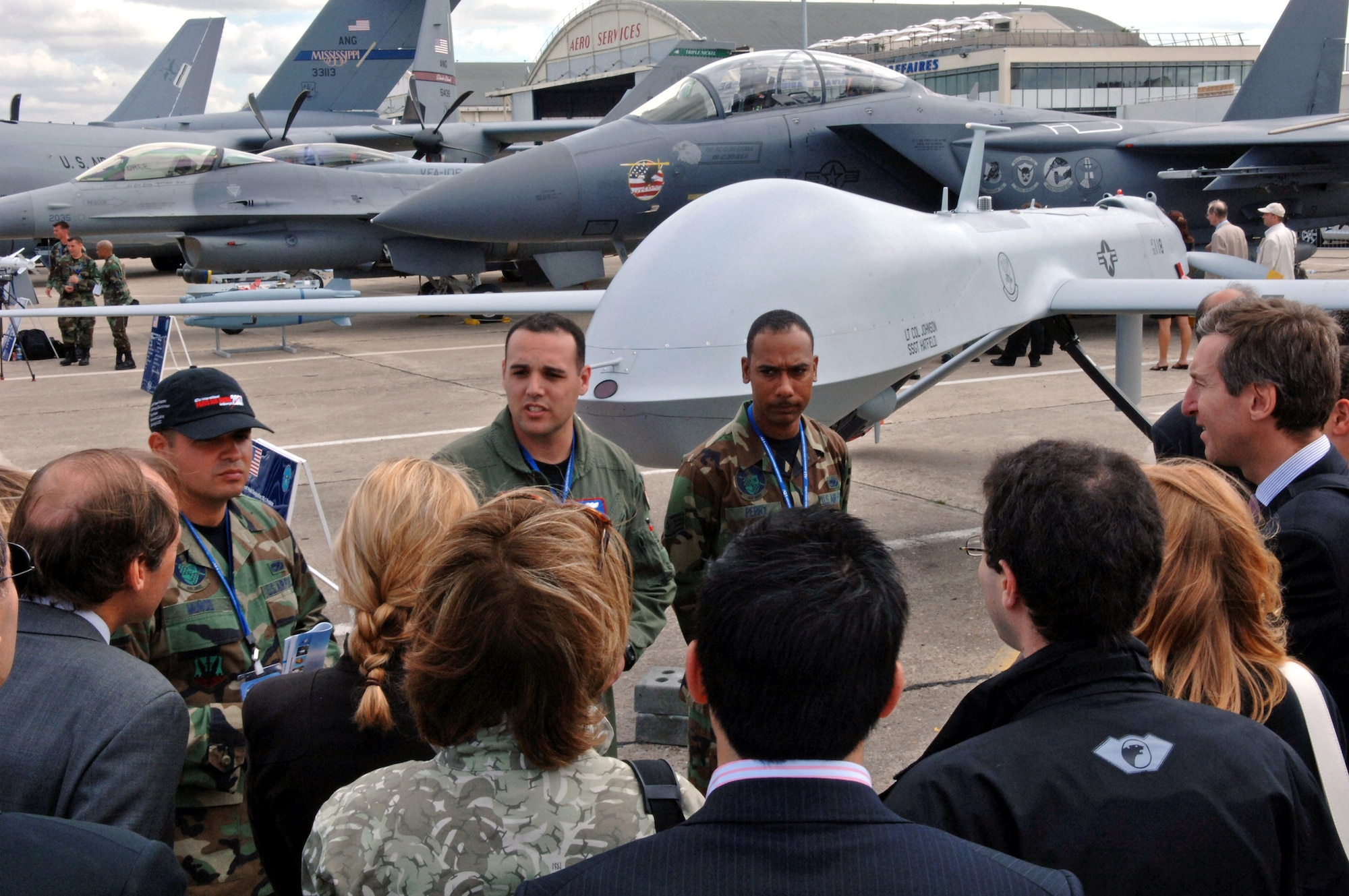 Staff Sgt. Angelo Munoz (from left), Capt. Chad Miner and Staff Sgt. Patrick Perry answer various questions about the MQ-1 Predator June 20 at the 47th International Paris Air Show at Le Bourget Airport, France. The Predator is one of seven Department of Defense aircraft on display this year. (U.S. Air Force photo/Airman 1st Class Marc I. Lane) 
