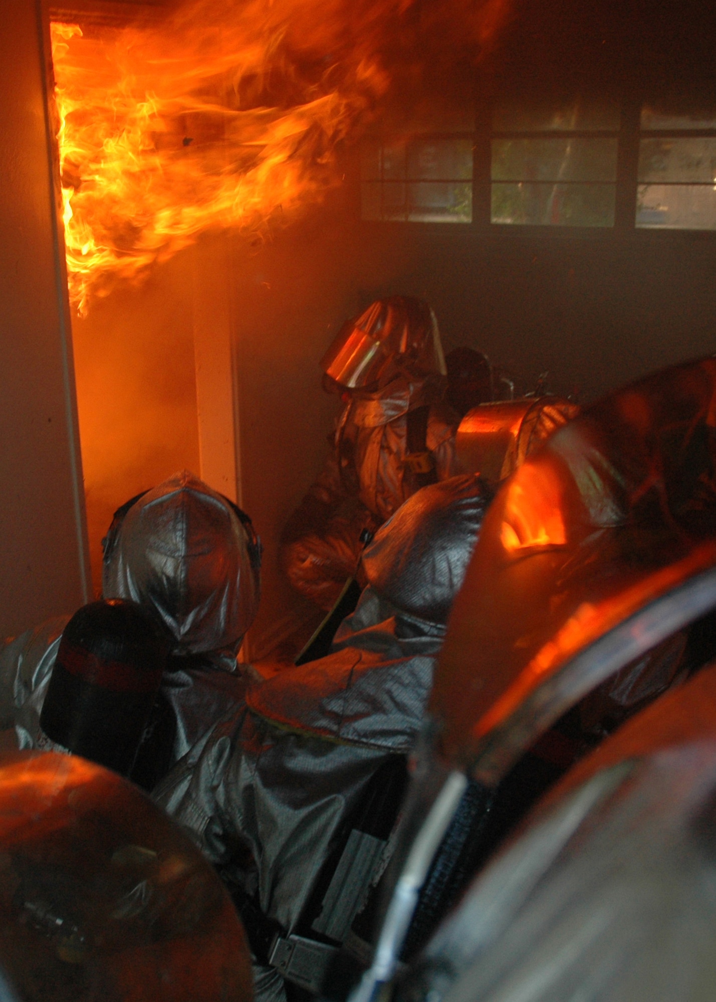 EGLIN AIR FORCE BASE, Fla. -- Firefighters with the 96th Civil Engineer Squadron Fire Department wait for a kitchen fire to reach its peak to see how it will react during a training exercise June 20. Eglin firefighters experienced the flames in a controlled scenario, part of a unique "real fire" training opportunity in base housing scheduled for demolition. Houses along Foster Drive, slated for demolition as part of Eglin's housing privatization initiative, were used for the training. (U.S. Air Force photo by Staff Sgt. Mike Meares)