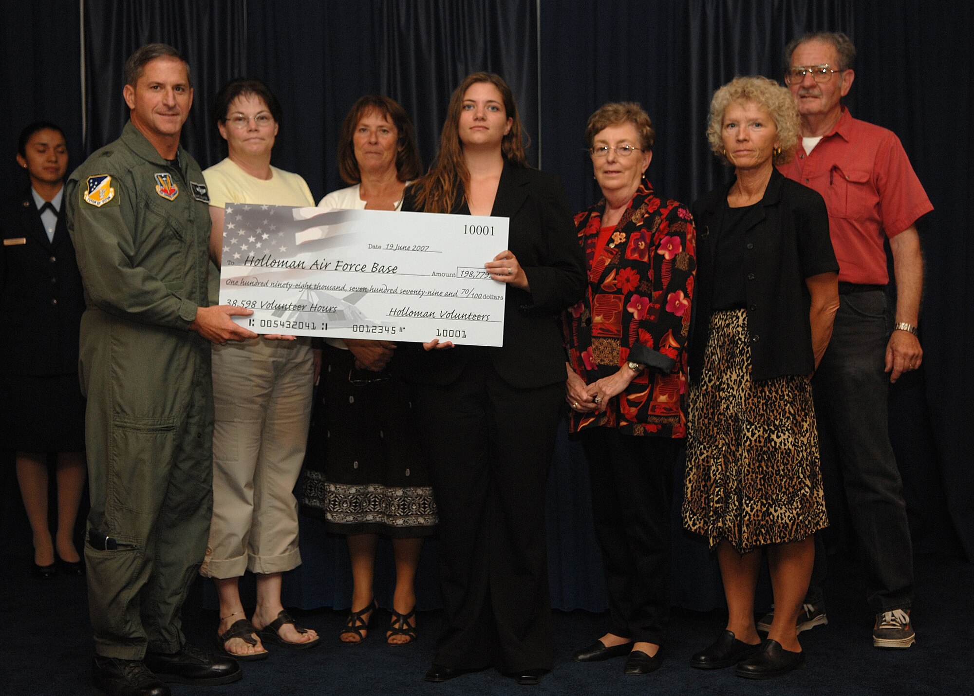 Brig. Gen. David Goldfein, 49th Fighter Wing commander, is presented a check by the Volunteer Advisory Committee symbolizing how much Holloman volunteers would have made if being paid the Alamogordo minimum wage. Holloman Airmen volunteered more than 38,500 hours equating to $198,779. (U.S. Air Force photo/Airman 1st Class John Strong)
