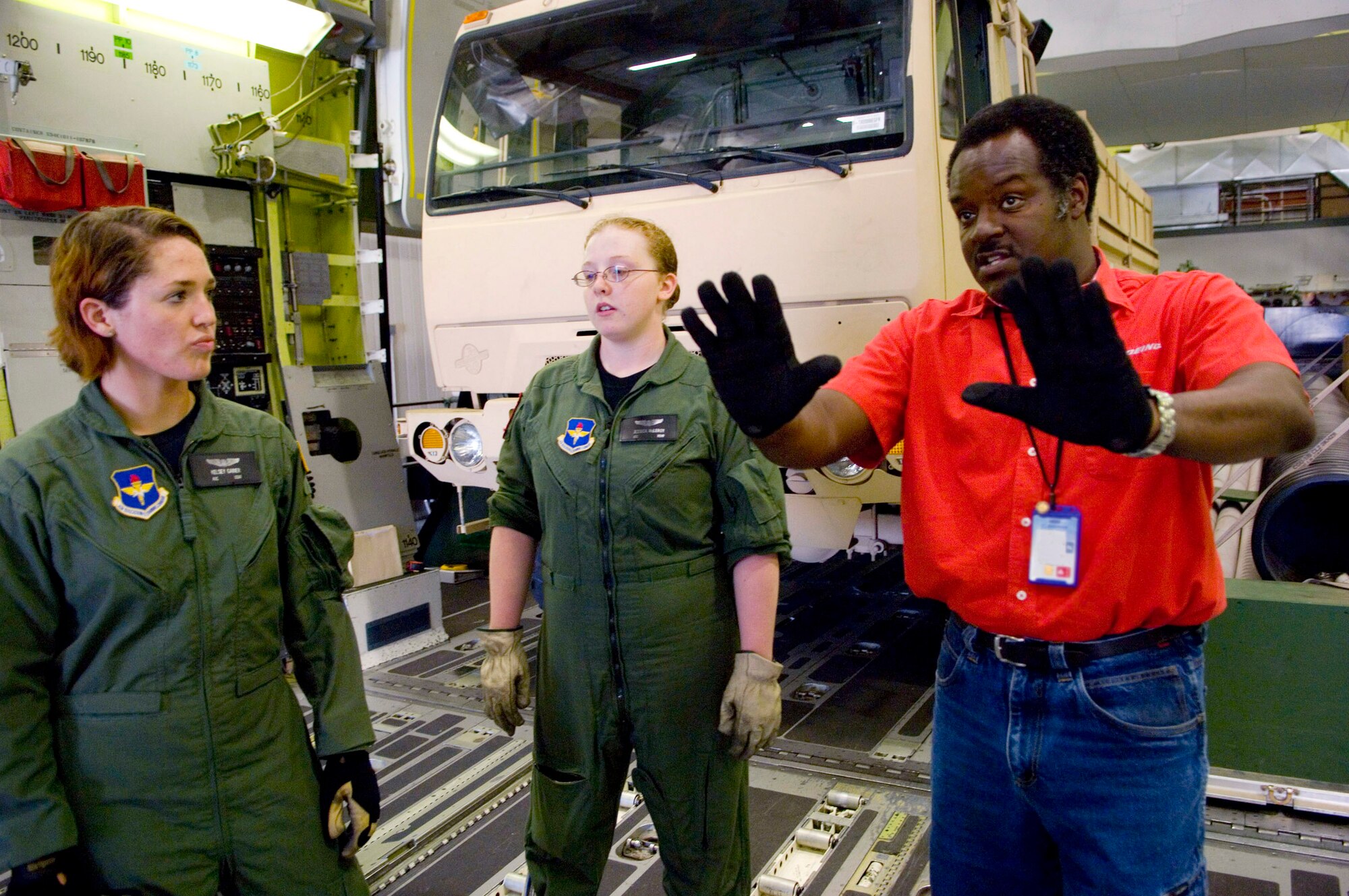 Howard Thagard, a loadmaster instructor with the C-17 Globemaster III aircrew training system instructs loadmaster students Airmen 1st Class Kelsey Gainer (left) and Jessica McLeroy in an $18 million cargo compartment trainer at Altus Air Force Base, Okla. Inside the simulated C-17 cargo compartment students get to try their hand at a variety of loads, to include pallets, vehicles, helicopters, heavy equipment and aeromedical set-ups. (U.S. Air Force photo/Tech. Sgt. Matt Hannen)
