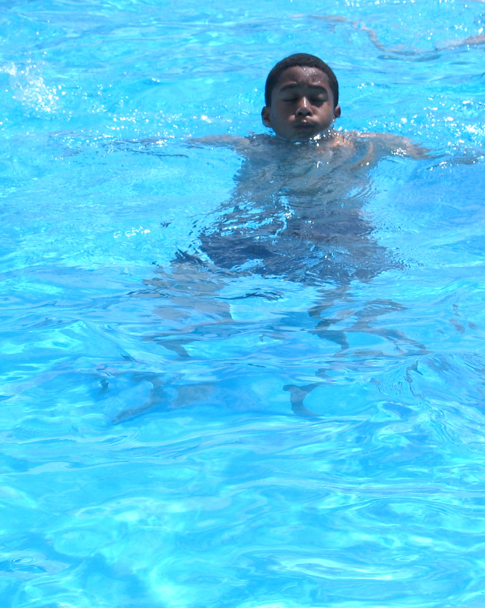 FAIRCHILD AIR FORCE BASE, Wash. – Kendall Dunn, 13, relaxes in the outdoor pool here June 20. Kendall is the son of Tech. Sgt. Albert Dunn, 92nd Logistics Readiness Squadron. Both the outdoor and indoor pools are open for business. The outdoor pool is open weekdays, 1 – 5 p.m., and weekends, noon – 5 p.m. (U.S. Air Force photo/Staff Sgt. Connie L. Bias) 