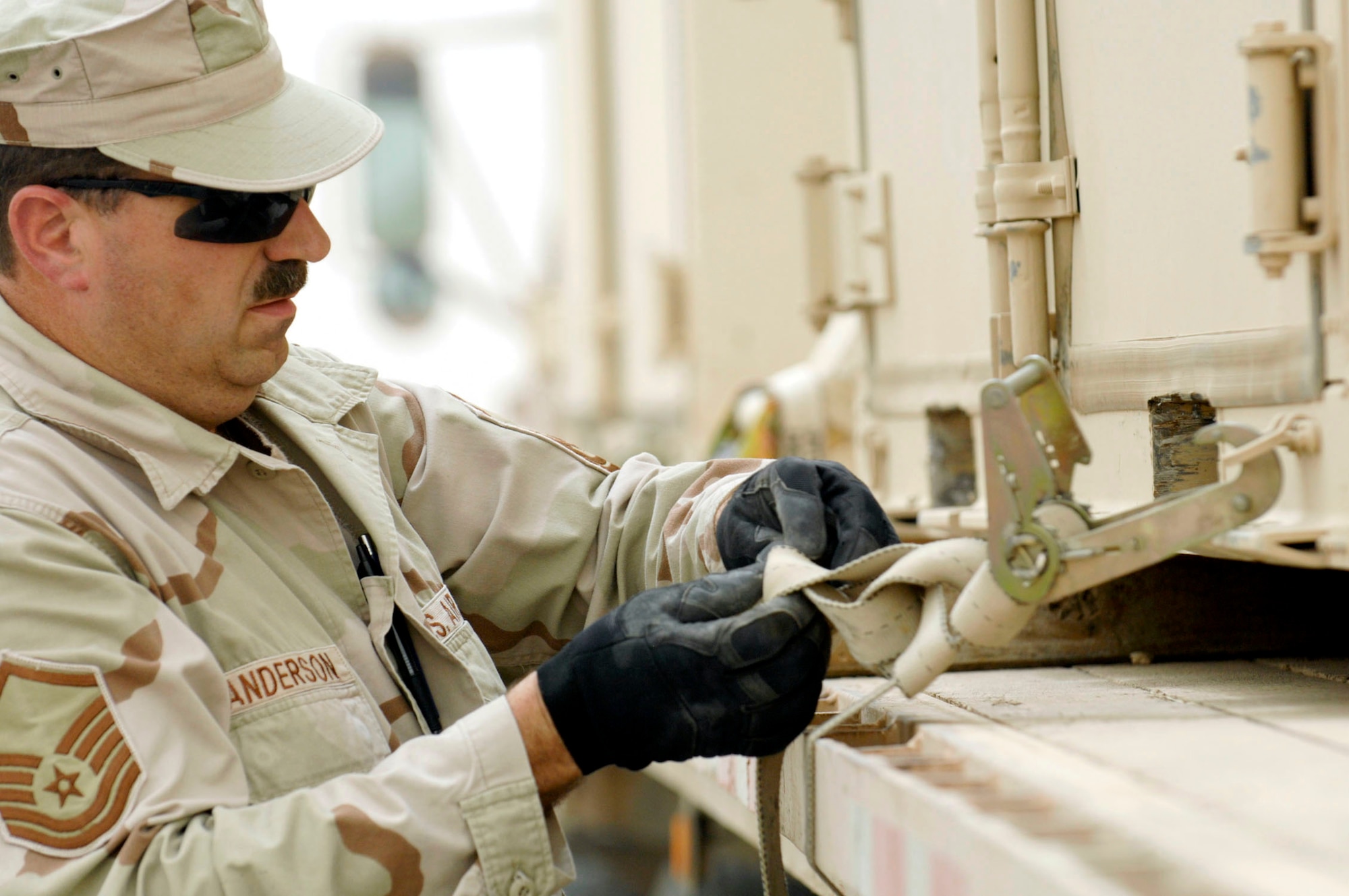 Master Sgt. Steven Anderson secures a container full of M-16s to a trailer during a base-wide arming exercise June 14 at Ali Air Base, Iraq. Ali AB Airmen participated in the exercise to help fine-tune weapons distributing procedures in case of a real-world threat to the base. Sergeant Anderson is assigned to the 407th Expeditionary Logistics Readiness Squadron. (U.S. Air Force photo/Master Sgt. Robert W. Valenca) 
