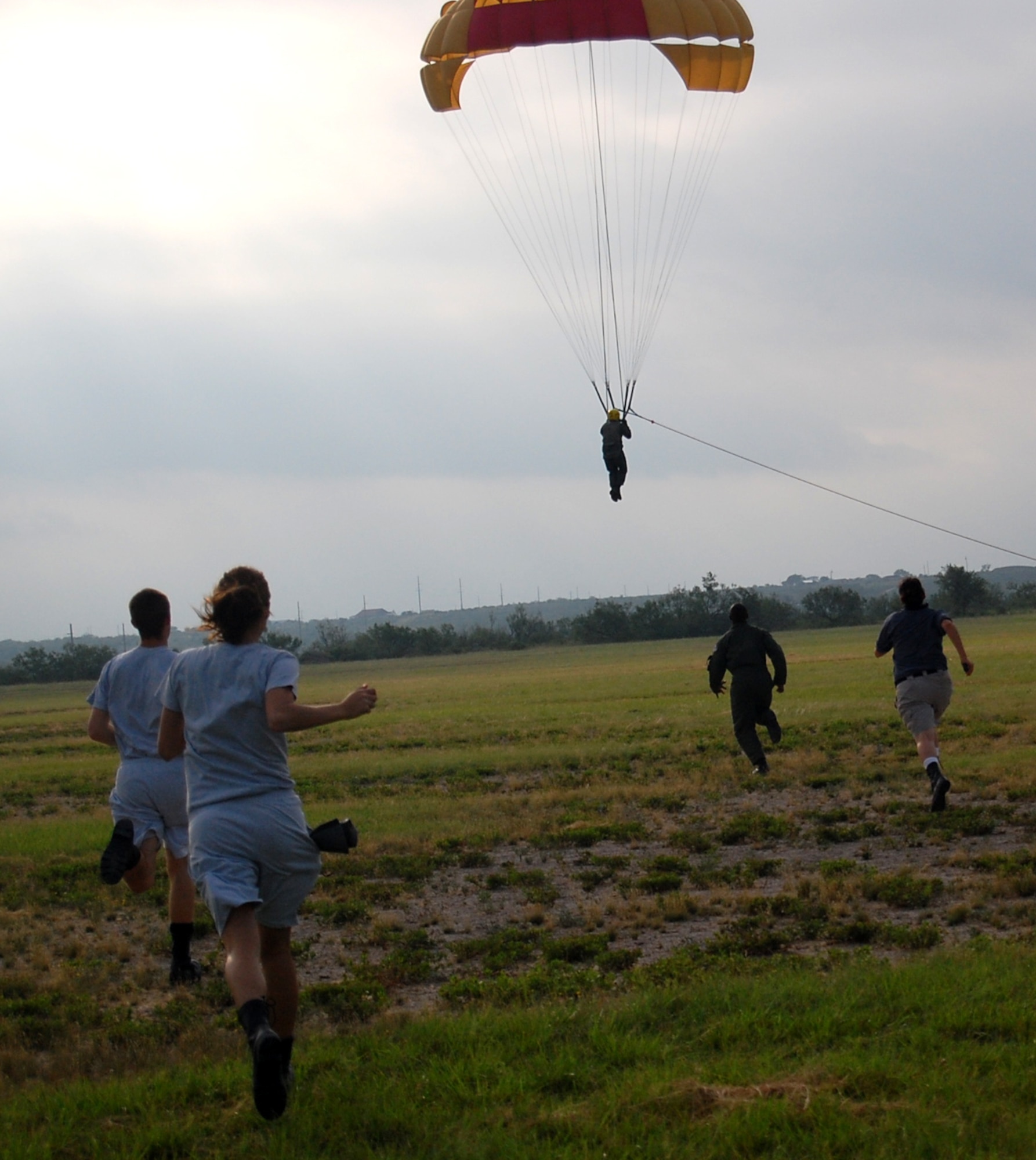 LAUGHLIN AIR FORCE BASE, Texas – Aerospace physiology technicians and their assistants rush to meet 2nd Lt. Seth Butler, SUPT class 08-11, as he touches down after a free fall from 600 feet beneath a parachute.  Students are taught proper landing procedures prior to the parasailing “flights” that ensure they reencounter the ground as safely as possible.  (U.S. Air Force photo by Airman Sara Csurilla)