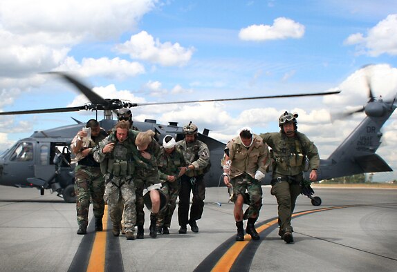 FAIRCHILD AIR FORCE BASE, Wash. -- Reservists from the 943rd Rescue Group, Davis-Monthan Air Force Base, Ariz., and the 304th Rescue Squadron, Portlant IAP, Ore., transfer mock casualties from their HH-60G Pave Hawk to a waiting C-130. The pararescue units teamed up for Patriot Angel, a Combat Search and Rescue exercise held here June 13 - 21. (U.S. Air Force photo/Staff Sgt. Paul Flipse) 