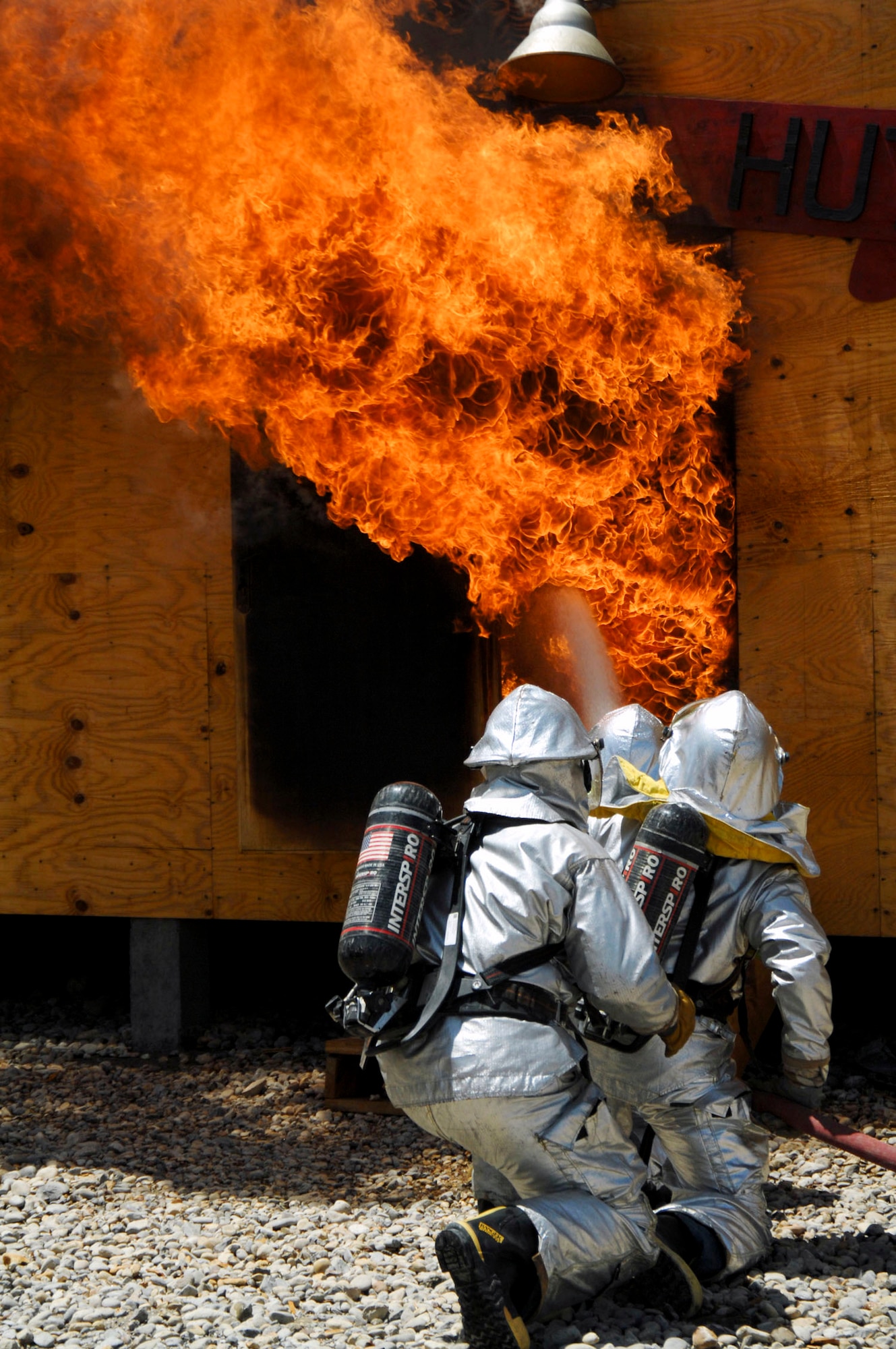 Firefighters perform an exterior attack on a fire in the Army Motor Pool June 19 on Camp Adder, Iraq. Due to munitions contained in the building and no potential for loss of life, the firefighters switched to defensive operations for the blaze using six trucks to keep it under control and confined to the building. The firefighters are from the 407th Expeditionary Civil Engineer Squadron at Ali Air Base, Iraq. (U.S. Air Force photo/Master Sgt. Robert W. Valenca) 
