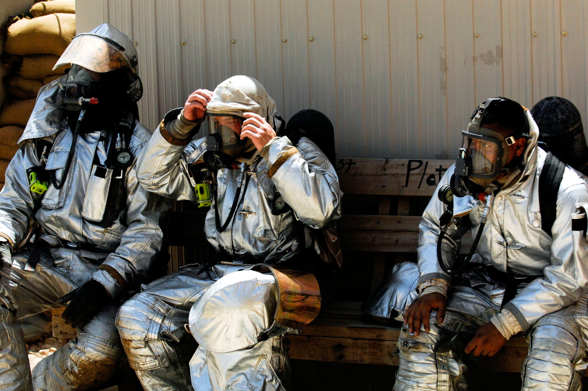 Firefighters rest after attempting an exterior attack on a fire in the Army Motor Pool June 19 on Camp Adder, Iraq. Due to munitions contained in the building and no potential for loss of life, the firefighters switched to defensive operations for the blaze using six trucks to keep it under control and confined to the building. The firefighters are from the 407th Expeditionary Civil Engineer Squadron at Ali Air Base, Iraq. (U.S. Air Force photo/Master Sgt. Robert W. Valenca) 

