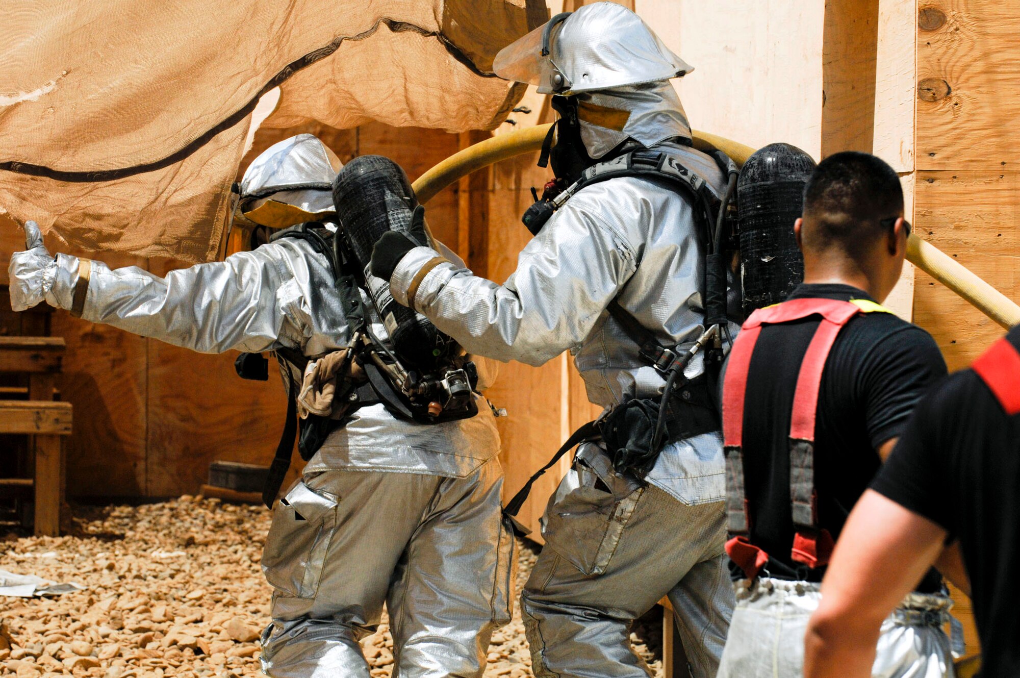 Firefighters head in to put out a blaze in the Army Motor Pool June 19 on Camp Adder, Iraq. Due to munitions contained in the building and no potential for loss of life the firefighters switched to defensive operations for the blaze using six trucks to keep it under control and confined to the building. The firefighters are from the 407th Expeditionary Civil Engineer Squadron at Ali Air Base, Iraq. (U.S. Air Force photo/Master Sgt. Robert W. Valenca) 
