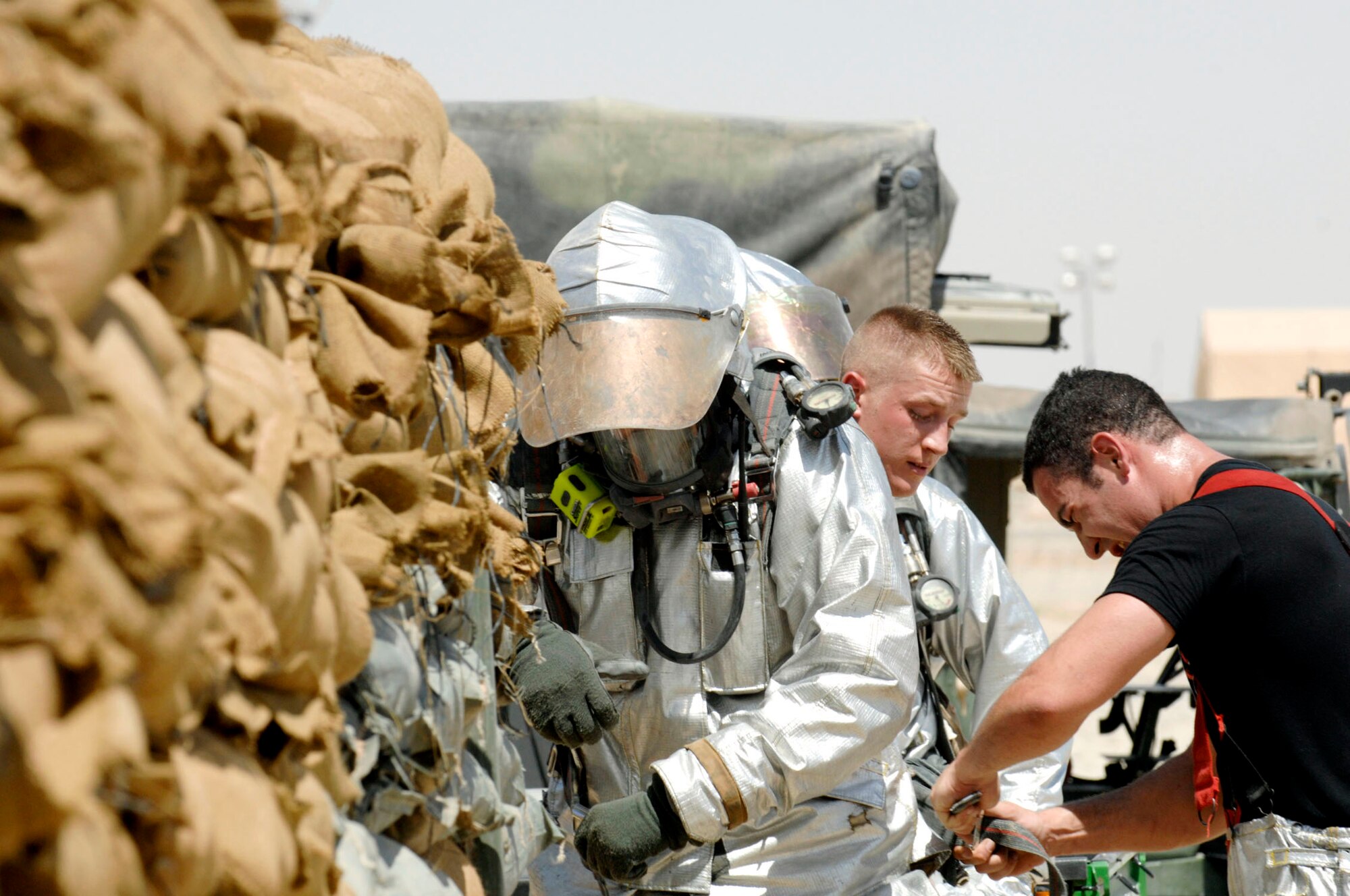 Firefighters perform a pre-entry safety check before attempting to battle a fire in the Army Motor Pool June 19 on Camp Adder, Iraq. Due to munitions contained in the building and no potential for loss of life, the firefighters switched to defensive operations for the blaze using six trucks to keep it under control and confined to the building. The firefighters are from the 407th Expeditionary Civil Engineer Squadron at Ali Air Base, Iraq. (U.S. Air Force photo/Master Sgt. Robert W. Valenca)