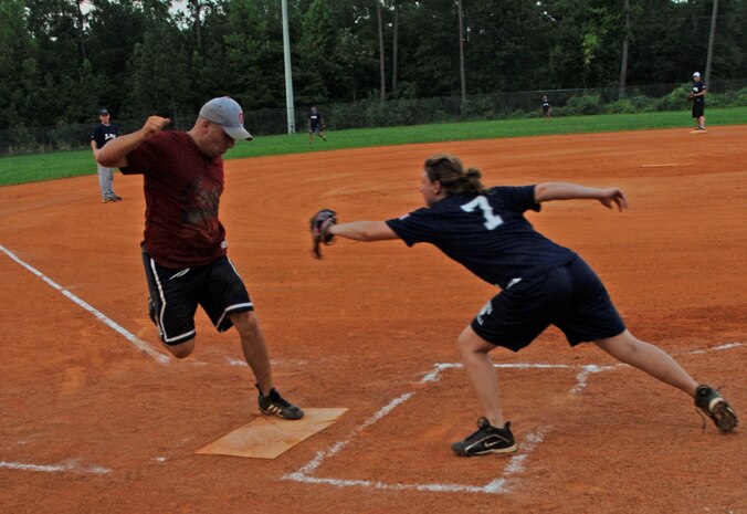 Todd Grabic, Security Forces Detachment 3, reaches home plate as Ashley Scott, 437th Logistics Readiness Squadron, tries to tag him out before scoring Tuesday. (U.S. Air Force photo/ Staff Sgt. April Quintanilla)