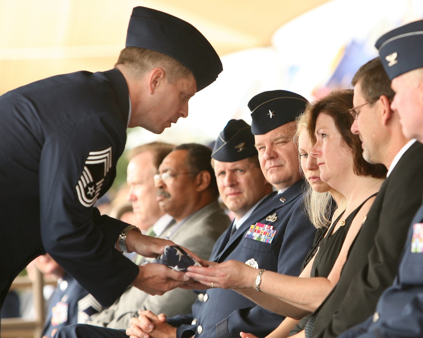 On behalf of a grateful nation,  Chief Master Sgt. Michael Tanguay, superintendent of the Air Force Office of Special Investigations 3rd Field Investigations Region, presents a folded American flag to Donna Kuglics, the mother of Special Agent Matthew Kuglics, during a memorial ceremony June 18 at Lackland Air Force Base, Texas. Agent Kuglics was killed in action by an improvised explosive while supporting Operation Iraqi Freedom. (USAF photo by Robbin Cresswell)
