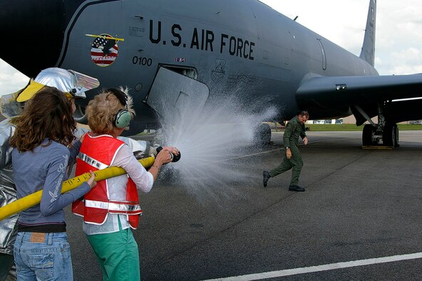 Col. Michael S. Stough, 100th Air Refueling Wing commander, makes a quck escape from his jet, tail number 0100 and the flagship of the wing, as his wife, Tracey, and daughter, Sarah, hose him down after his fini flight June 20. (U.S. Air Force photo by Karen Abeyasekere)
