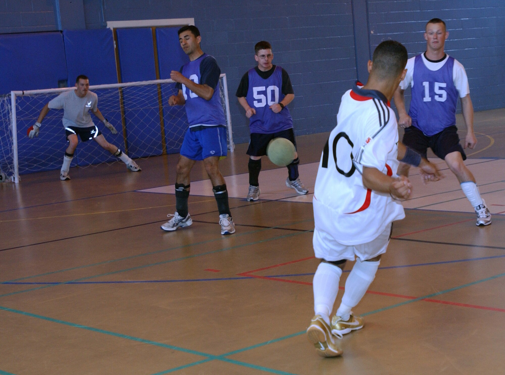 Mike Dedousis, 727th Air Mobility Squadron shoots on goal while 100th Logistics Readiness Squadron players Oscar Figueroa, David Beasley, Timothy Moore and goalie Richard Mast defend. The 727th AMS defeated the 100th LRS 1 team 4-0 to cruise to the intramural soccer championship game at the RAF Mildenhall northside gym. (Air Force photo by Airman Brad Smith).