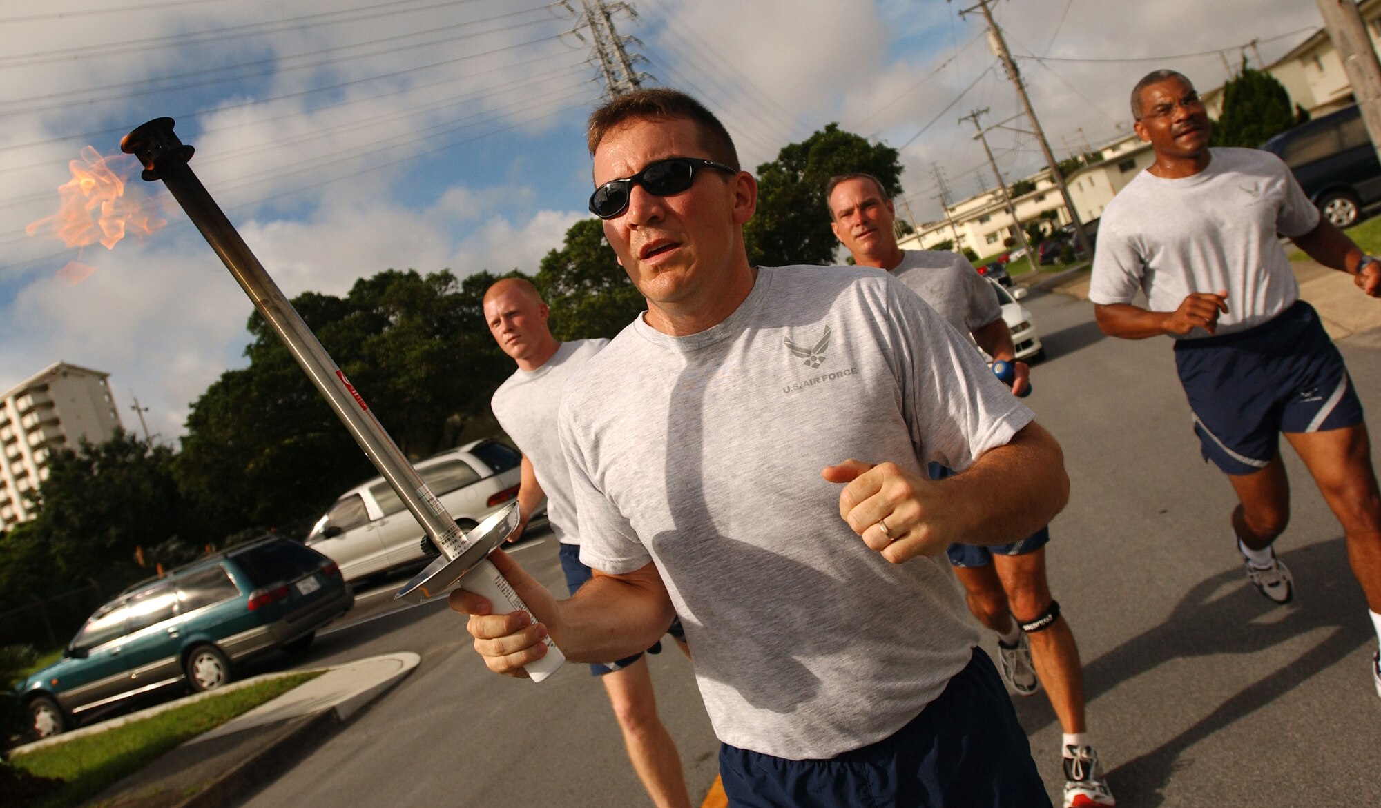 Tech. Sgt. Matt Howard, 18th Security Forces Squadron, leads a four-man team as they run from Gate 2 to Bldg. 705 before starting the Law Enforcement Torch Run at Kadena Air Base, Japan. Army, Navy, and Marines joined the run from Bldg. 72 to the Risner Gym June 16. The Torch Run is affiliated with Special Olympics nation wide and was adopted at Kadena to promote awareness for the annual event here.  (U.S. Air Force photo by Staff Sgt. Reynaldo Ramon)