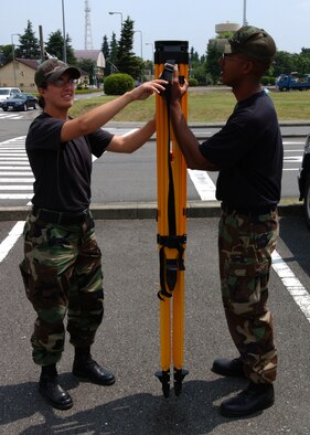YOKOTA AIR BASE, JAPAN -- Staff Sergeant Kevin Howell and Senior Airman Christine Beyea, both from the 374th Civil Engineer Squadron, set up a tripod for a piece of Global Positioning Statellite (GPS) equipment on June 21, 2007.  The equipment is designed to transmit GPS mapping data to satellites in order to improve existing satellite maps. (U.S. Air Force photo by Airman First Class Jonathan Fowler)                               