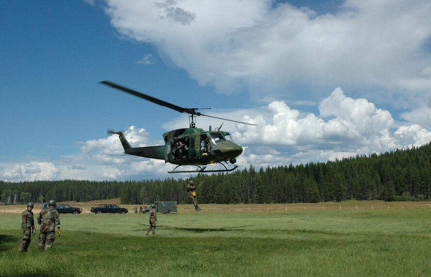 A UH-1N "Huey" hoists a Survival, Evasion, Resistance, Escape Specialist Training student at a landing zone north of Fairchild Air Force Base, Wash.  (U.S. Air Force photo by Tech. Sgt. Michael Darvis)


