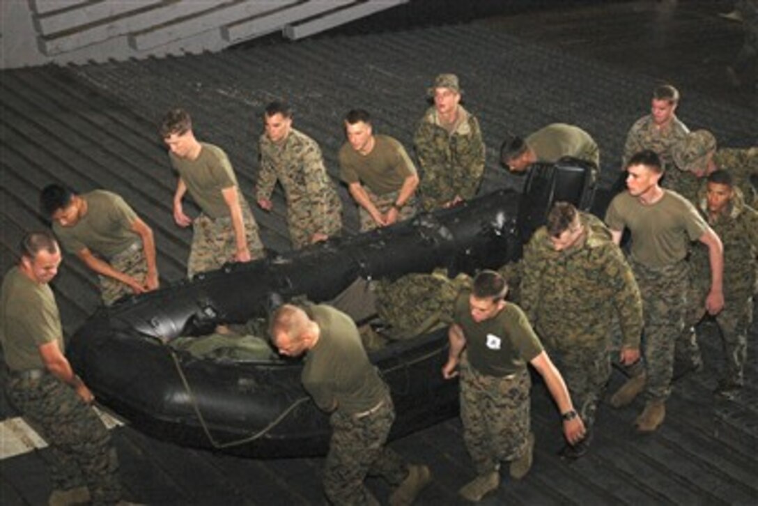 Members of 31st Marine Expeditionary Unit transport the combat rubber raiding craft on board amphibious landing dock USS Juneau after the completion of the landing craft utility recovery operations during Exercise Talisman Saber, June 20, 2007.  