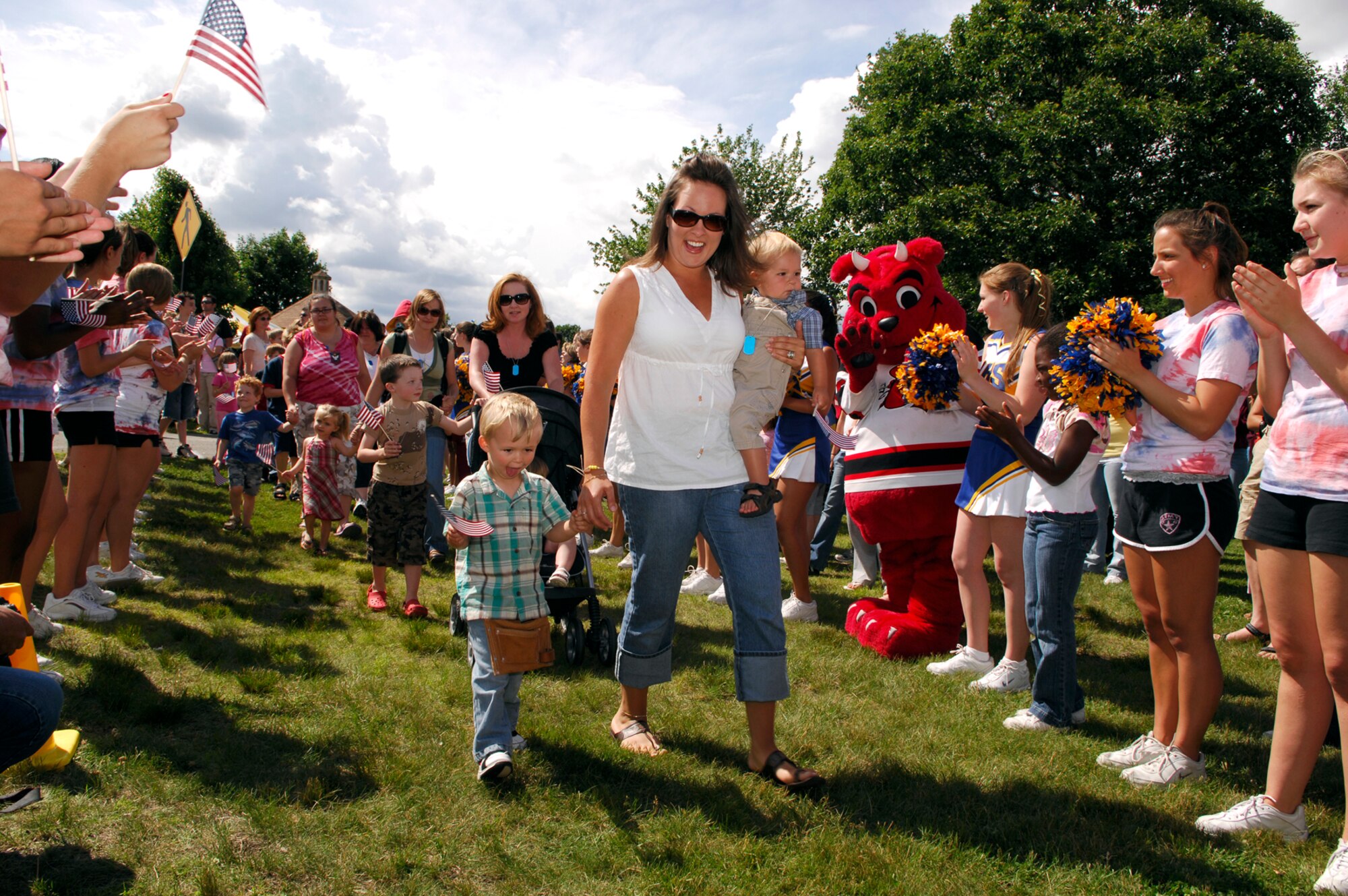 Families of the recent deployers marched into a cheering crowd waving American flags during Hanscom’s Heroes’ Homecoming event held June 22.  During the celebration the community formally welcomed home over 60 servicemembers who had deployed within the last 6 months. Hundreds of base personnel, family and friends gathered during the ceremony.  (US photo by Mark Wyatt)