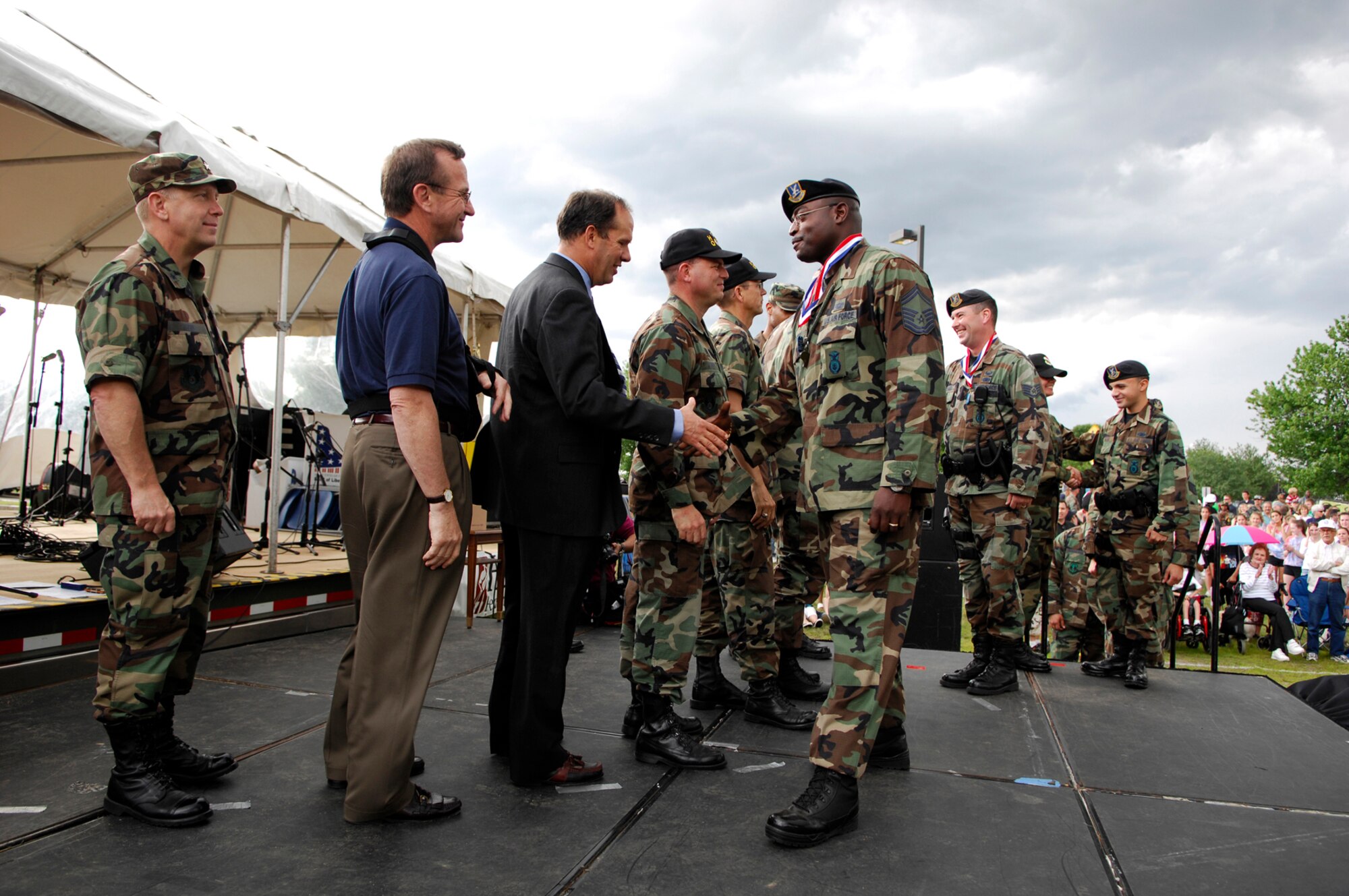 Senior Master Sgt. Woodrow Carter, 66th Security Forces Squadron, exchanges a handshake with Bruce Hevey, 653rd Electronic Systems Wing director, during Hanscom’s Heroes’ Homecoming event held June 22. Base leadership lined the stage to formally welcome home over 60 servicemembers who had deployed within the last 6 months. Hundreds of base personnel, family and friends gathered during the ceremony.  (US photo by Mark Wyatt)