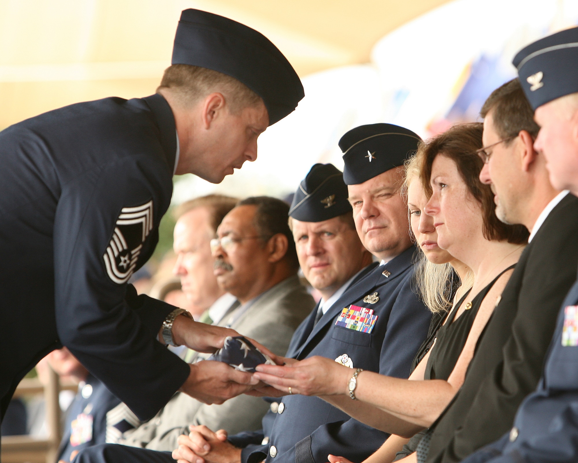 Chief Master Sgt. Michael Tanguay, superintendent of the Air Force Office of Special Investigations 3rd Field Investigations Region, presents a folded American flag to Donna Kuglics, the mother of Special Agent Matthew Kuglics, during a memorial ceremony June 18 at Lackland Air Force Base, Texas. Agent Kuglics was killed in action by an improvised explosive while supporting Operation Iraqi Freedom. (U.S. Air Force photo/Robbin Cresswell)