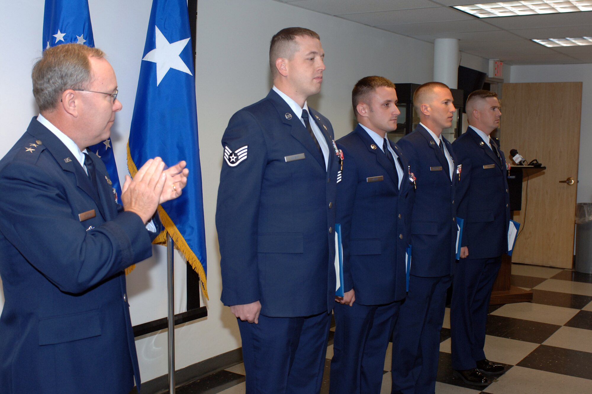 Maj. Gen. Kevin J. Sullivan, Ogden Air Logistics Center commander, presents Staff Sgts. Bradley Kline, Evan Knight, Steven Overstreet and William White. The Airmen, from the 775th Civil Engineer Squadron, Explosive Ordnance Disposal Flight, were presented the award for their efforts in the Global War on Terror (U.S. Air Force photo by Alex P. Llloyd)