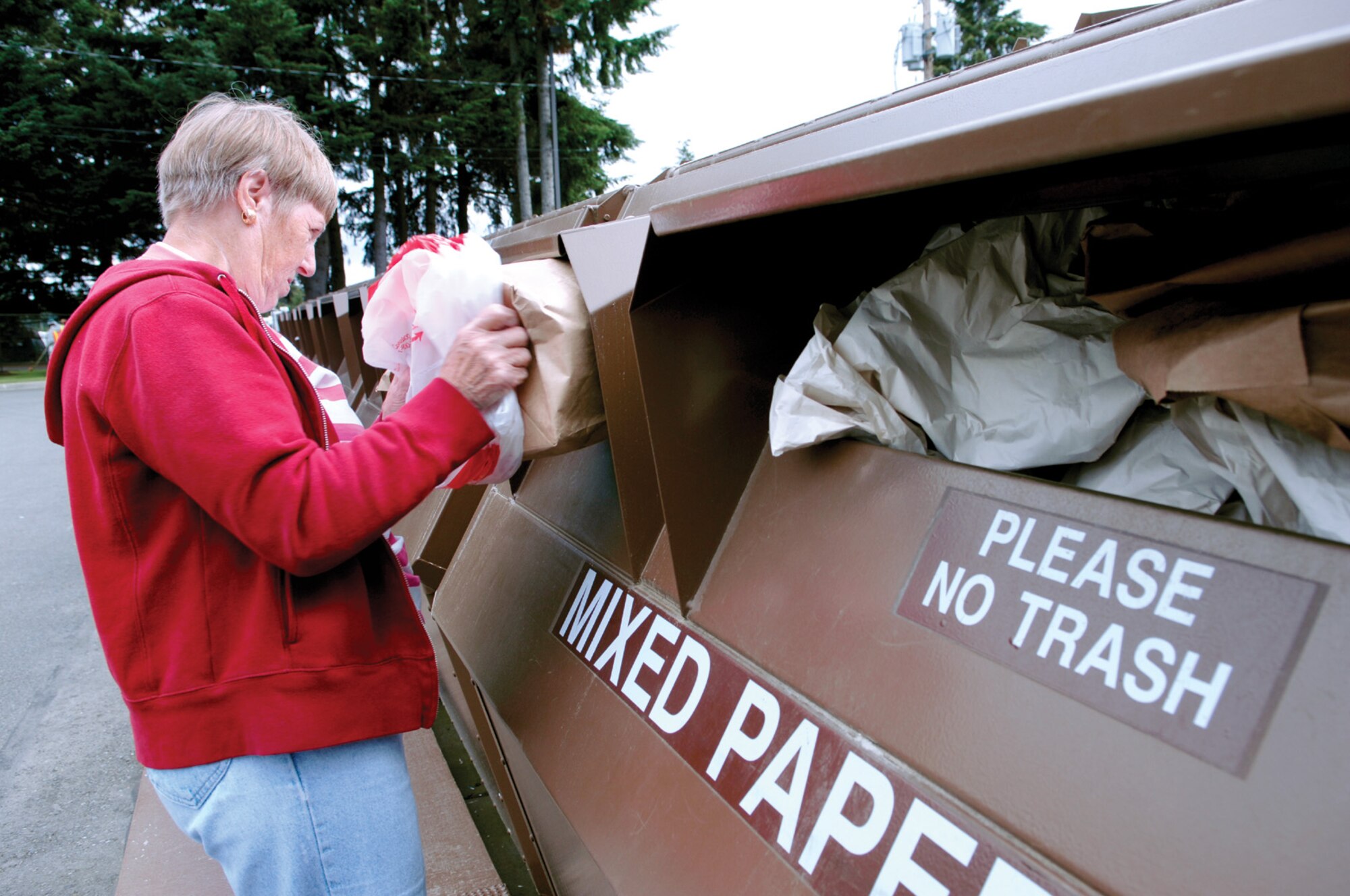 MCCHORD AIR FORCE BASE, Wash. -- Eva Carmona, a regular visitor to McChord's recycling center, places paper products into one of several containers located in the center's parking lot, June 18. (U.S. Air Force photo/Abner Guzman)