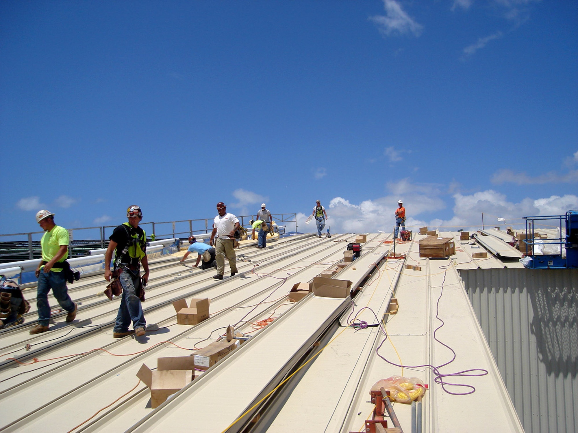 URS employees, contracted by the Air Force Center for Engineering and the Environment, use metal siding to install the roof of the new C-17 Globemaster III Corrosion Control Hangar at Hickam Air Force Base, Hawaii. The hangar will be used for painting and general maintenance functions for the eight C-17 aircraft assigned to Hickam AFB. (U.S. Air Force photo/Capt. Kevin Syzmanski)
