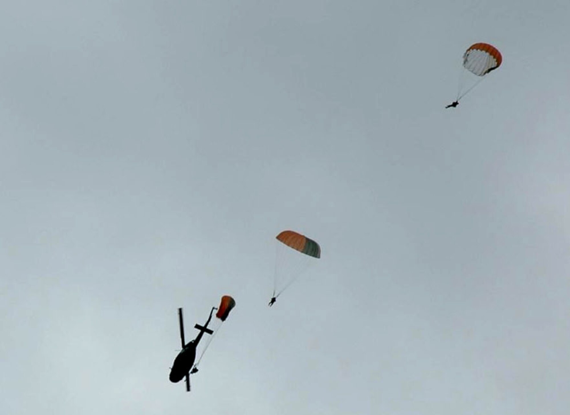 Students practice static line parachuting techniques from a UH-1N Huey assigned to the 36th Rescue Flight at Fairchild Air Force Base, Wash. The jumpers are performing demo drops for students attending survival school. The 36th RQF supports this school, along with survival, evasion, resistance and escape specialist training, and also responds to civilian search and rescue requests through the National Search and Rescue Plan. (U.S. Air Force photo) 