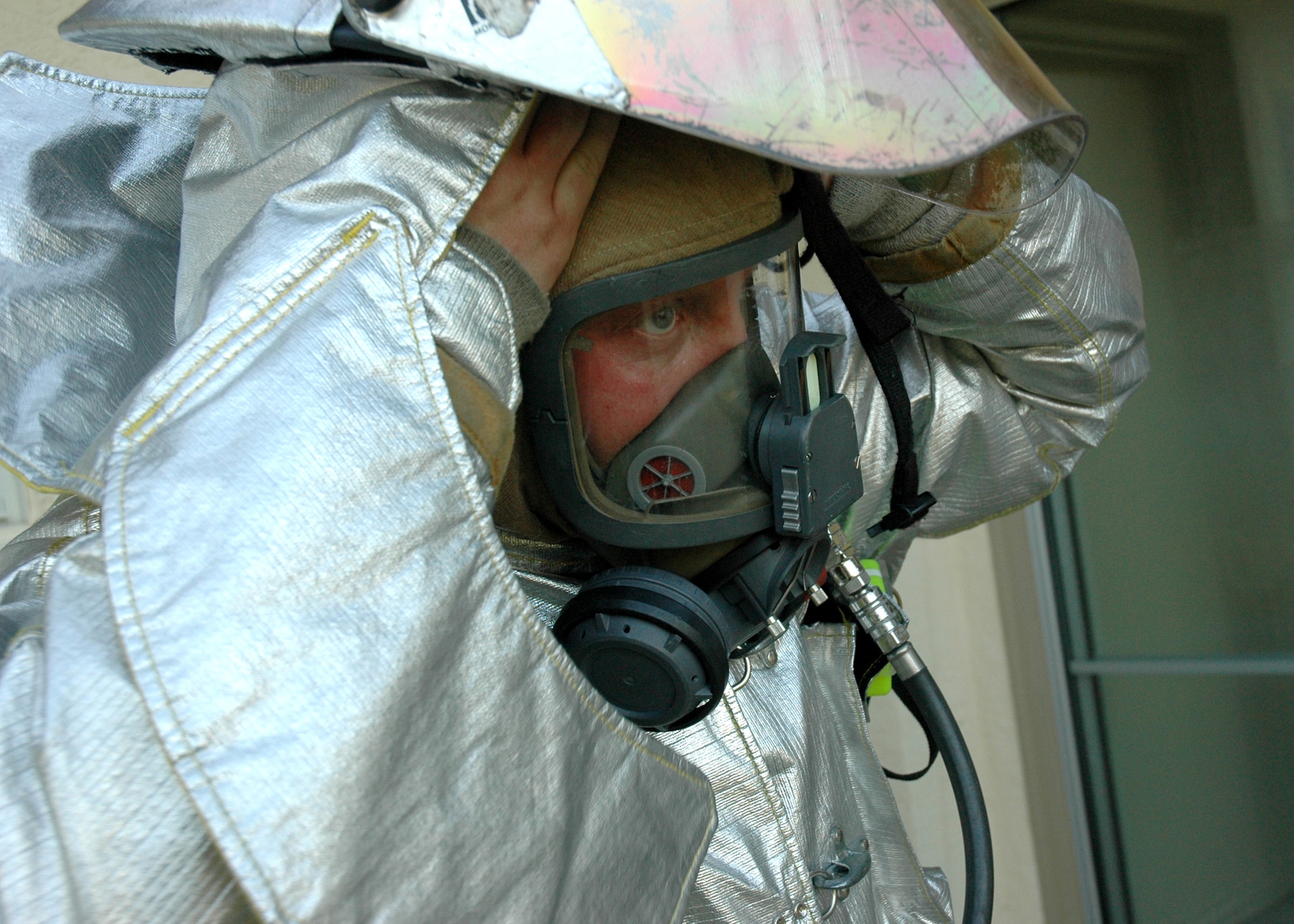 EGLIN AIR FORCE BASE, Fla. -- Kyle Kruger, a 96th Civil Engineer Squadron firefighter, suits up to battle a training fire if it gets out of hand during a training exercise June 20 in base housing. Eglin firefighters experienced the flames in a controlled scenario, part of a unique "real fire" training opportunity. Houses along Foster Drive, slated for demolition as part of Eglin's housing privatization initiative, were used for the training. (U.S. Air Force photo by Staff Sgt. Mike Meares)