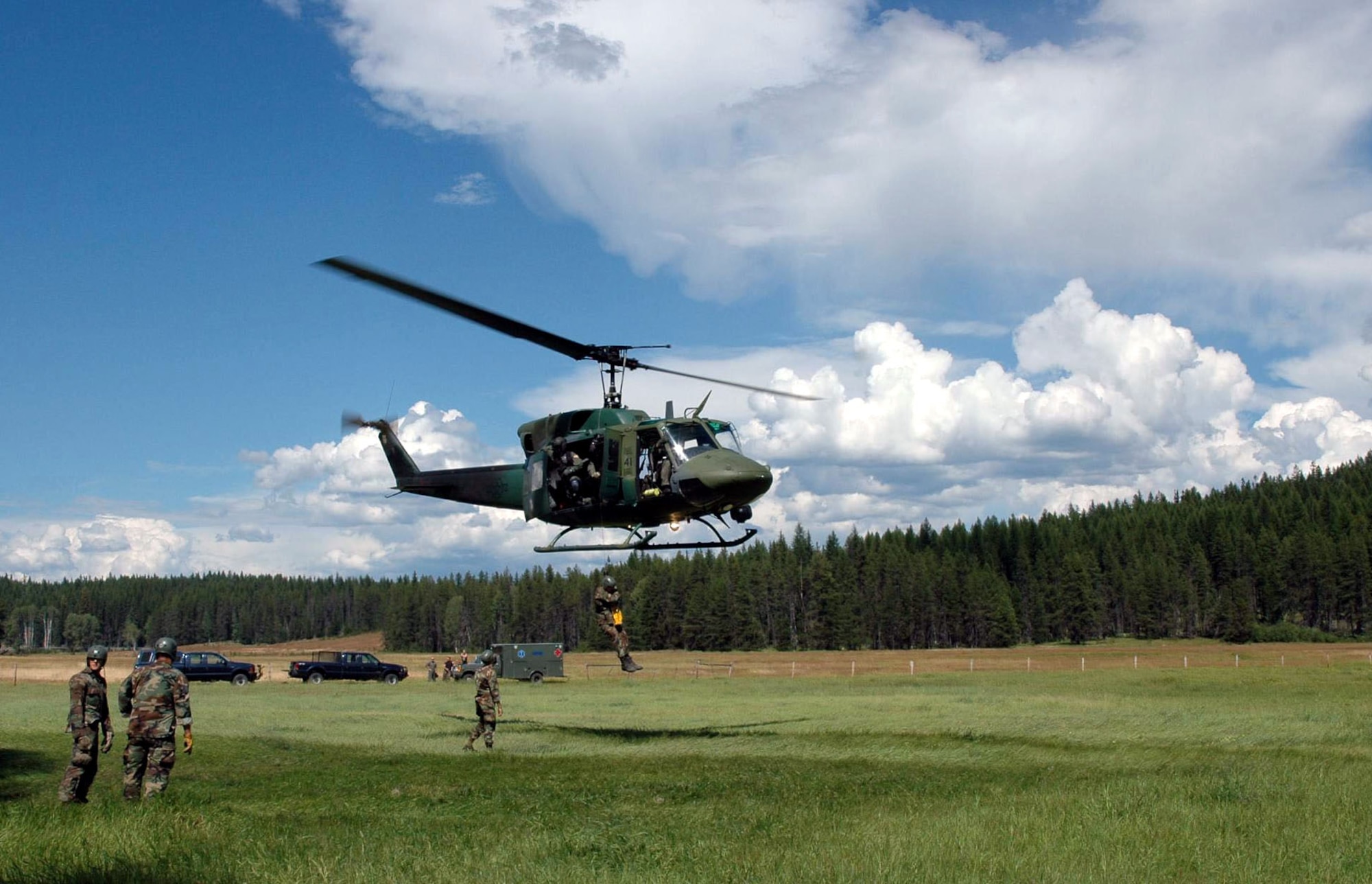 A UH-1N Huey hoists a survival, evasion, resistance and escape specialist training student at a landing zone north of Fairchild Air Force Base, Wash. The 36th Rescue Flight supports the Air Force combat survival school, survival, evasion, resistance and escape specialist training, and supports the National Search and Rescue Plan for some off-base civilian emergencies.(U.S. Air Force photo/Tech. Sgt. Michael Darvis)