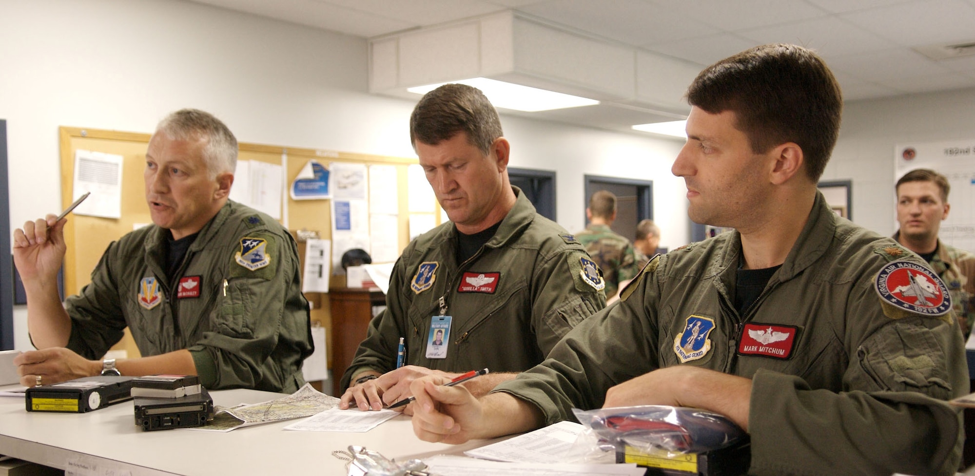 From left: Lt. Col. Mark McCauley, Col. Charles Smith, and Maj. Mark Mitchum, F-16 pilots with the 192nd Virginia Air National Guard Unit in Sandston, Va., receive their last  flight brief as F-16 pilots with the 192nd June 20. For the past two years, the 192nd has been integrating with the 1st Fighter Wing here as part of the Total Force Initiative. Pilots from the 192nd are transitioning from F-16 Falcons to F-22A Raptors and belong to the first Air National Guard Unit to fly the Raptor. (U.S. Air Force Photo/Staff Sgt. Samuel Rogers)
