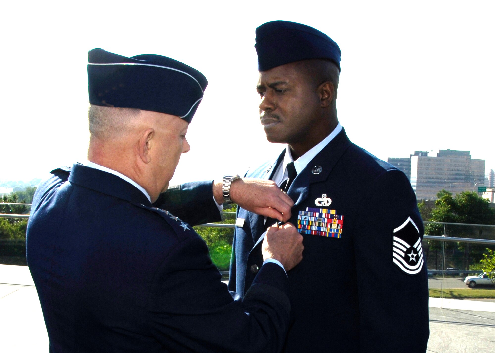 Air Force Chief of Staff Gen. T. Michael Moseley presents Master Sgt Charlie Peterson of the 927th Logistical Readiness Squadron, Selfridge Air National Guard Base, Mich., the Air Force Combat Action Medal during a ceremony at the Air Force Memorial in Arlington, Va., on June 12, 2007.  General Moseley presented six Airmen with the medal. Master Sgt. Peterson is the first Air Force Reservist to be given the medal which recognizes Airmen who distinguished themselves while engaged with hostile forces in the performance of their duties. (U.S. Air Force photo/Staff Sgt. Amaani Lyle)
