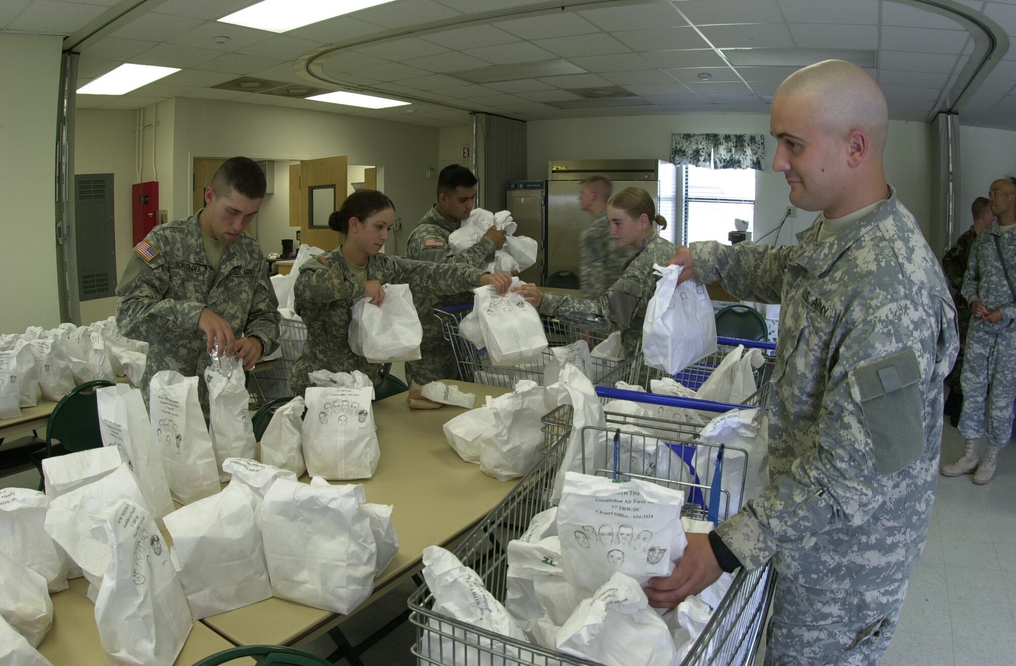 (From left to right): Army Pvts. Anson Sokoloff, Alysha Rivera, and Brian Begeal, as well as Pfc. Verna Milner and Pvt. Wesley Arnold, all student Soldiers from the  344th Military Intelligence Battalion, help put bags of food into shopping carts June 15 at the Fellowship Hall.

The carts were used to distribute free meals to hundreds of people around Goodfellow Air Force Base. The Soldiers were part of a group of 17 student Soldiers and five student Airmen who helped prepare 1,000 bagged-meals for the 2007 Picnic with the Padres, a bi-annual base appreciate event sponsored by the 17th Training Wing Chapel Office. The picnic is customarily held in conjunction with the Annual Army vs. Air Force Coed Softball Game or the Army vs. Navy flag football game, held later in the year.

A recognition ceremony for recently-deployed servicemembers from Goodfelow usually takes place during a break in the softball game.  This year’s picnic was postponed due to inclement weather. The date and time of the rescheduled events will be available at a later date. (U.S. Air Force photo by Airman 1st Class Luis Loza Gutierrez)