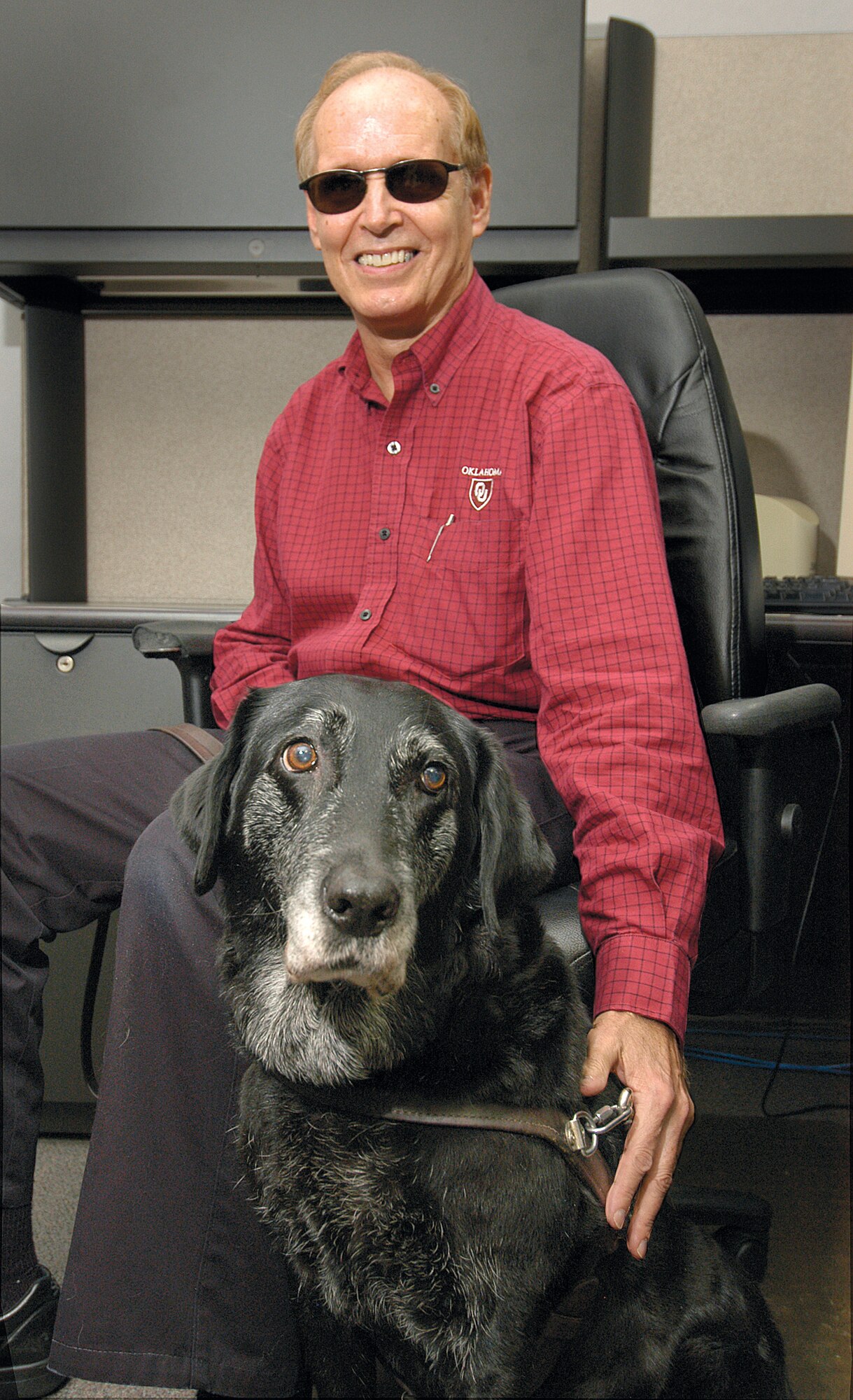 After more than nine years of being the eyes and trusted friend to Scott Moffett, Sapphire retired this week. Mr. Moffett, a Tinker phone operator, has relied on his friend to guide him through the maze of Bldg. 3001 and other buildings since shortly after coming here in 2000. (Air Force photo by Margo Wright)
