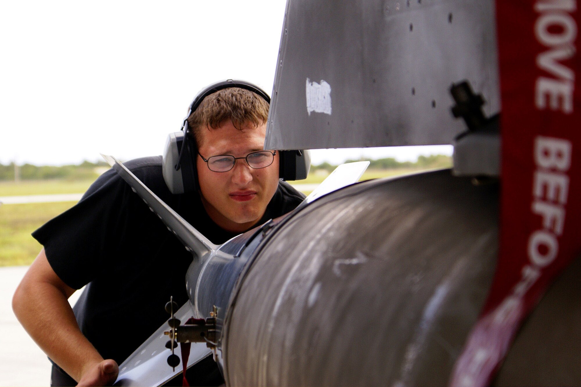 Senior Airman Shawn Dietz guides an MK-84 bomb into place on an F-16 Fighting Falcon June 21 at Andersen AFB, Guam. Airman Dietz is a weapons load crew member from the 27th Aircraft Maintenance Squadrom at Cannon AFB, N.M. Members of the 27th AMXS are deployed to Andersen AFB for four months, and are currently participating in Exercise Cope North. (U.S. Marine photo/Lance Cpl. Danny Restivo) 