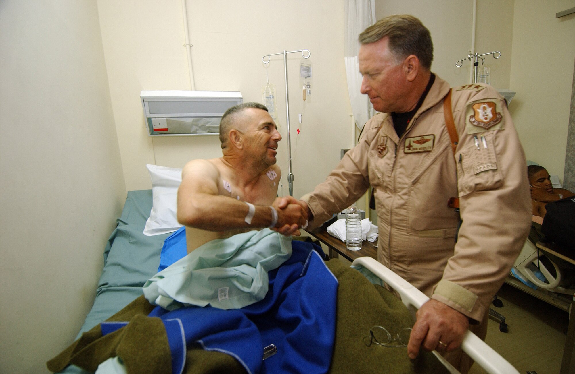 Lt. Gen. John A. Bradley, commander of Air Force Reserve Command, visits Master Sgt. Thomas Coffin at the Air Force Theater Hospital at Balad Air Base, Iraq, on June 15, 2007. Sergeant Coffin, deployed from the AF Reserve's 4th Combat Camera Squadron, was recovering from a gunshot wound. (U.S. Air Force photo/Tech Sgt. Rick Sforza)