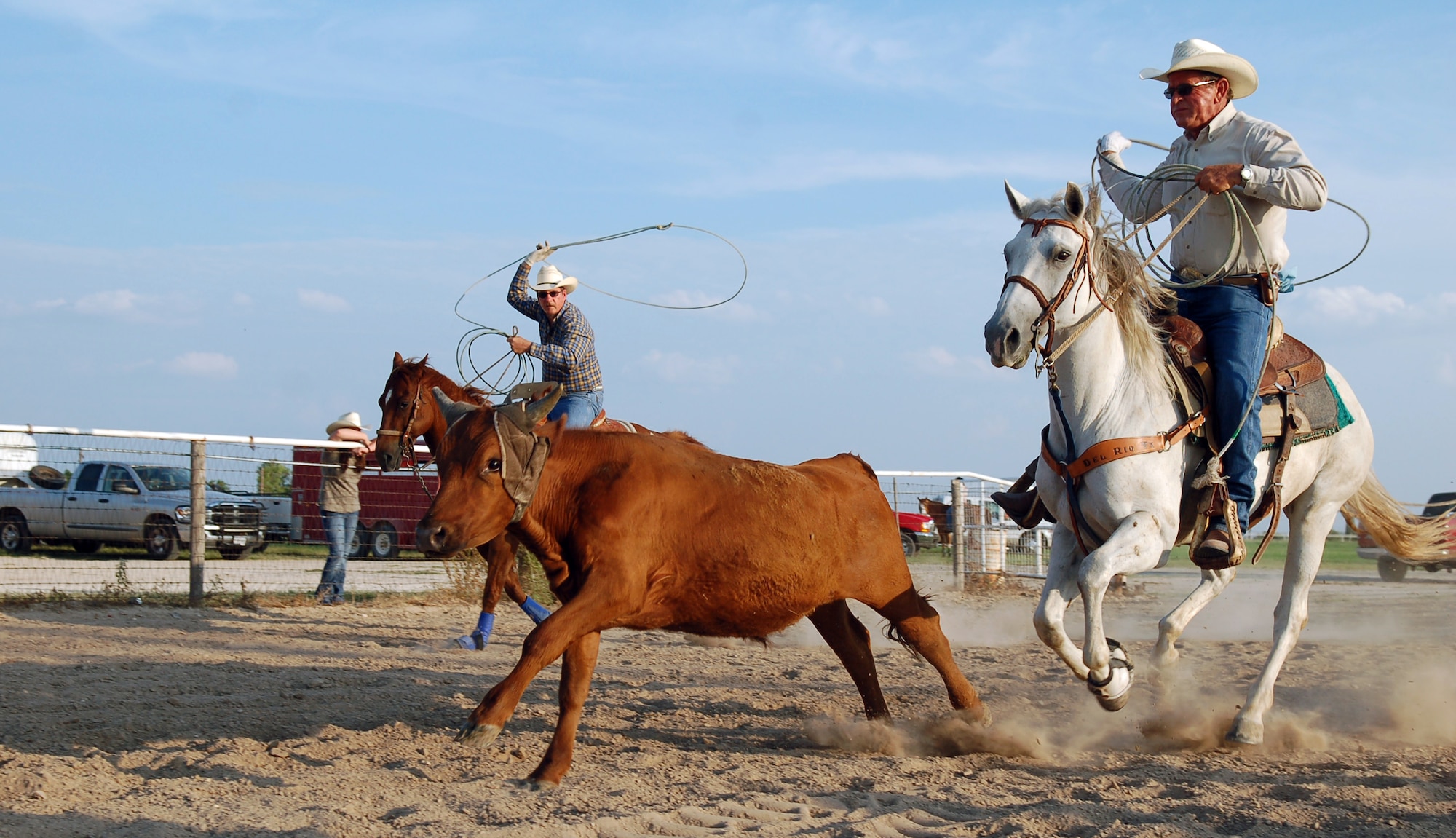 DEL RIO, Texas – As a steer barrels out of its holding gate at Val Verde County Fairgrounds, retired Master Sgt. Jeff Scott (background), project manager for the 47th Communications Squadron, and his teammate Kelsey Johnson stay close behind in an attempt to rope the animal as quickly as possible.  (U.S. Air Force photo by Staff Sgt. Austin M. May)