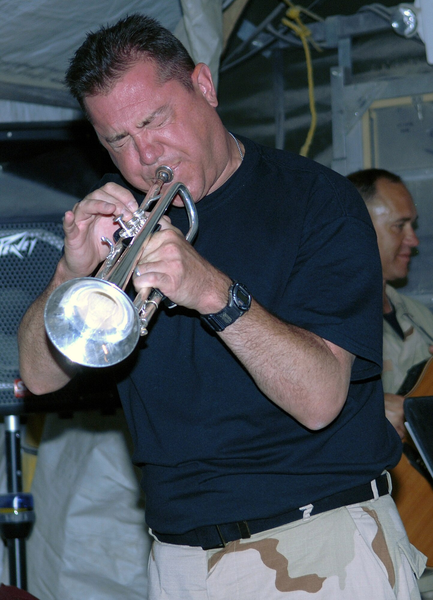 Staff Sgt. Marcel Marchetti, CENTAF band trumpet player, hits a high note during an impromptu performance at Bagram Airfield, Afghanistan June 19. Sergeant Marchetti also served as the evening's emcee, introducing the members of the band to the Airmen of the 455th Air Expeditionary Wing. (photo by Staff Sgt. Craig Seals)
