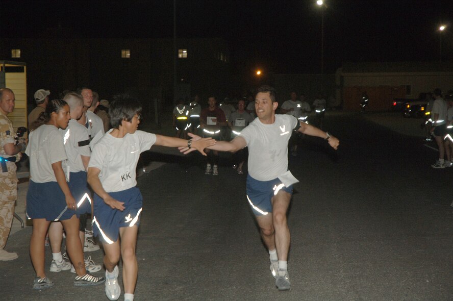 1st Lt. Luis Morales (right) tags Lt. Col. Rhonda Toba (left) during a half marathon organized by members of the British Royal Air Force Tuesday. (U.S. Air Force photo by Master Sgt. Ken Stephens)