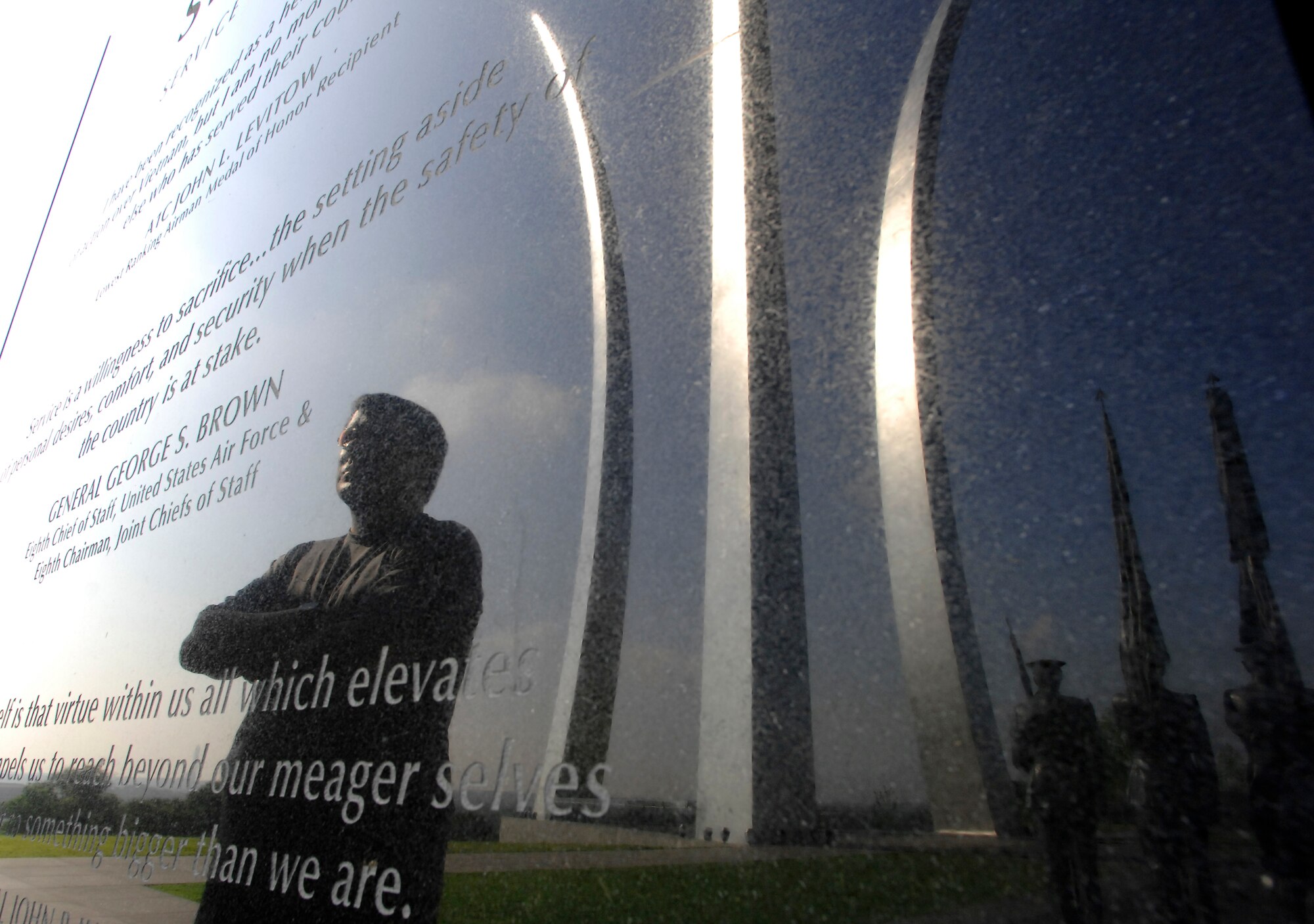 "Airman Magazine" writer Orville Desjarlais looks over the granite inscription wall at the Air Force Memorial in Arlington, Va., during a trip to cover several news events in the Washington area.  The memorial's three soaring spires, reflected in the wall, represent the flying spirit of the Air Force.  (U.S. Air Force photo/Staff Sgt. Brian Ferguson)