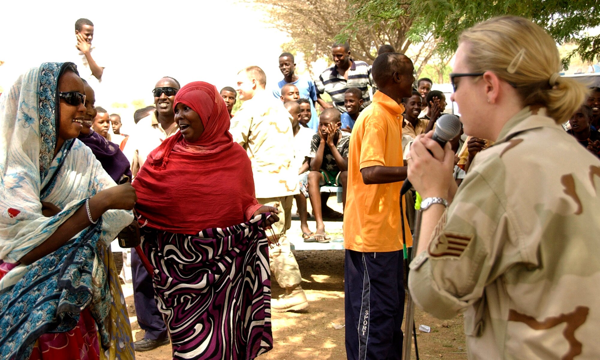 Staff Sgt. Amy Layhew gets the village ladies up and dancing as she sings during "Thunder Roll's" outreach concert in Douda village June 20. This was the first time a band had ever played in the village, located five miles from Camp Lemonier, Djibouti. Sergeant Layhew is a vocalist and keyboard player with the U.S. Central Air Forces expeditionary band.  (U.S. Air Force photo/Staff Sgt. Samuel King Jr.) 