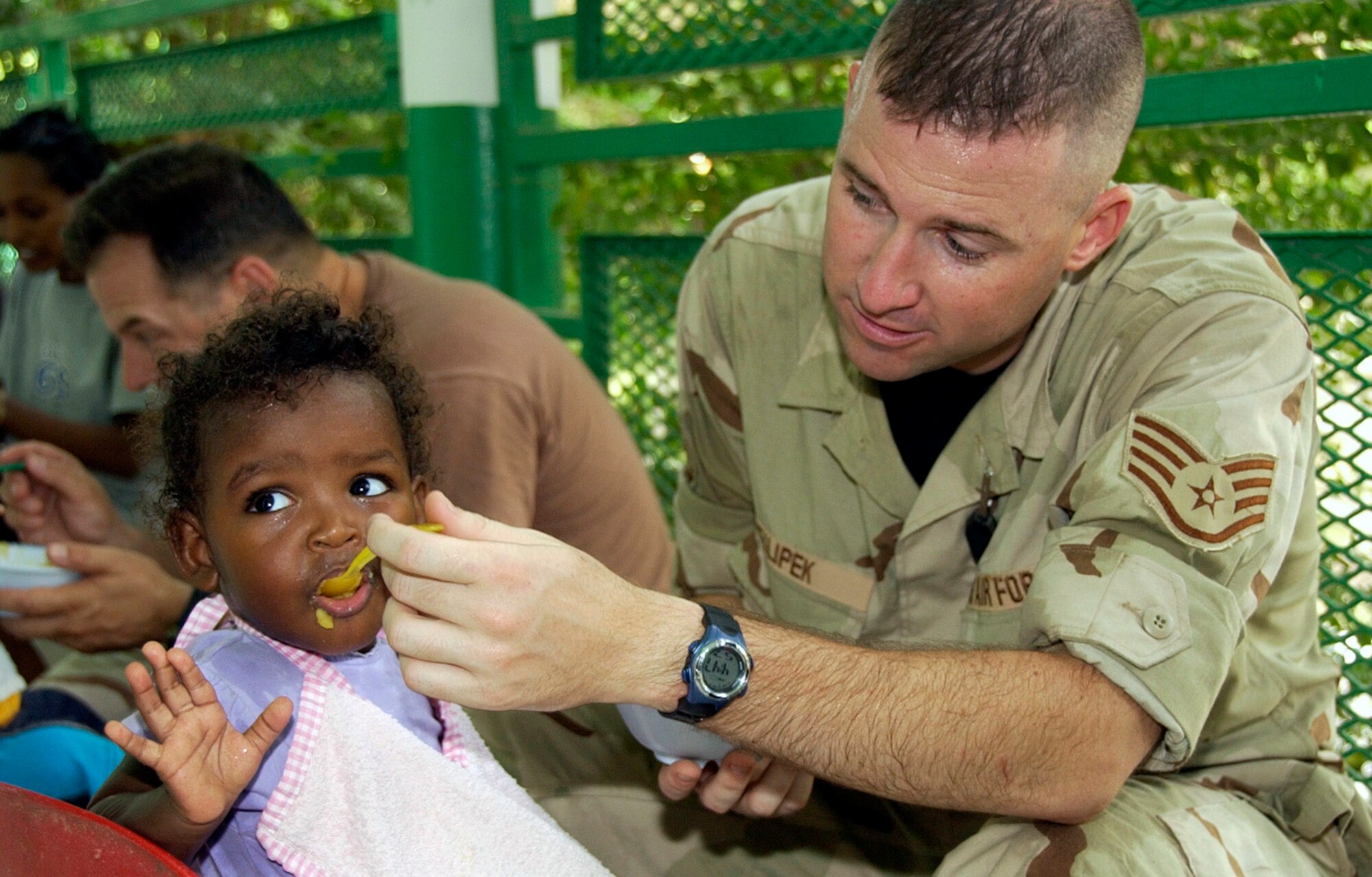 Staff Sgt. Joe Filipek feeds an infant during a visit to a baby orphanage June 19 near Camp Lemonier, Djibouti. Sergeant Filipek, an Illinois Air National Guardsman, is a drummer with the U.S. Central Air Forces expeditionary band "Thunder Roll." The band visited Camp Lemonier and Dijbouti during a five-day concert tour. (U.S. Air Force photo/Staff Sgt. Samuel King Jr.) 