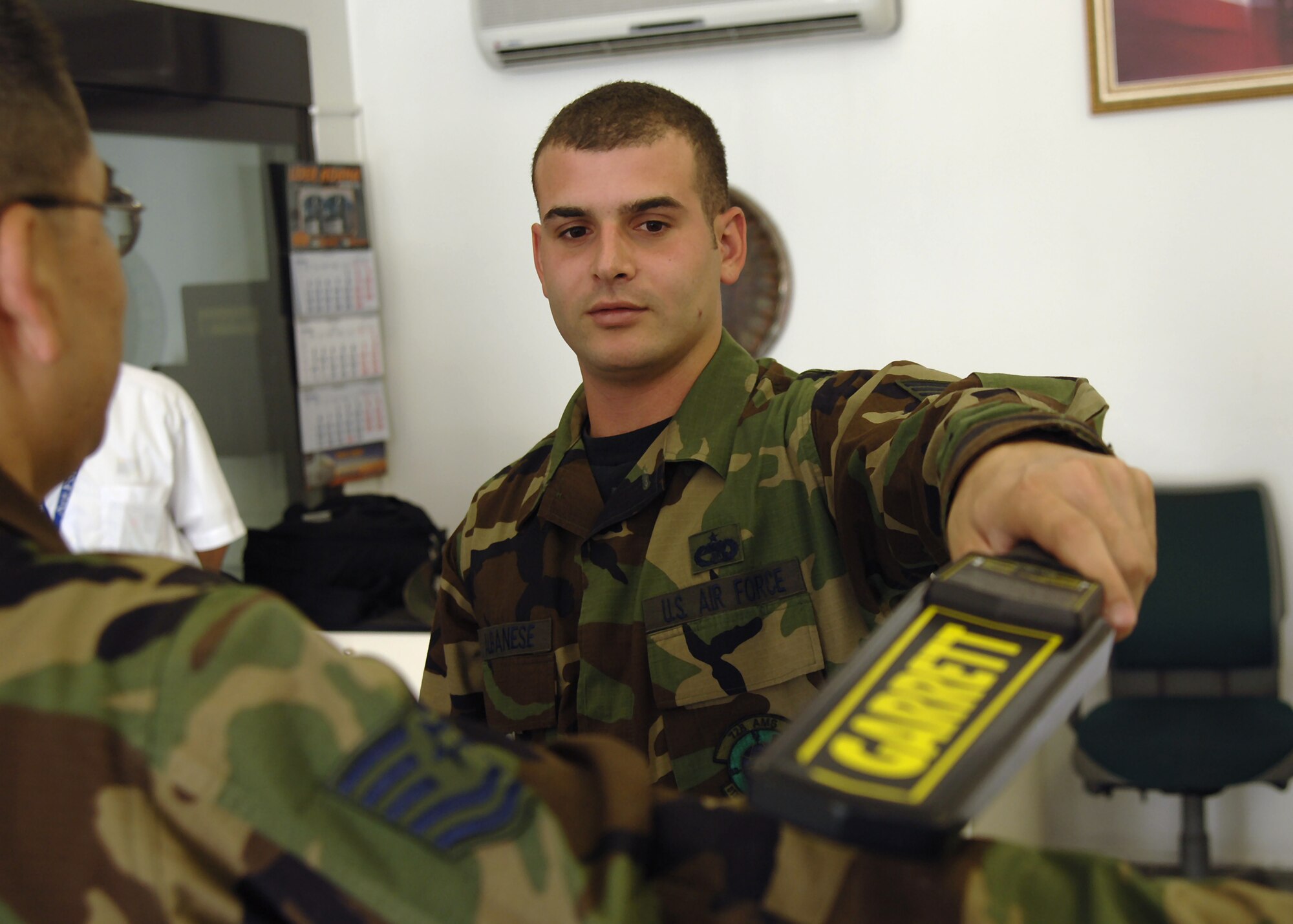 Staff Sgt. David Albanese, 728th Air Mobility Squadron passenger service agent, performs a passenger security screening at the passenger terminal, June 20.  Without the dedicated service of the squadron's passenger service agents, travelers would not make it to their final destinations comfortably or safely, if at all.  (U. S. Air Force photo by Tech. Sgt. Brian Jones)