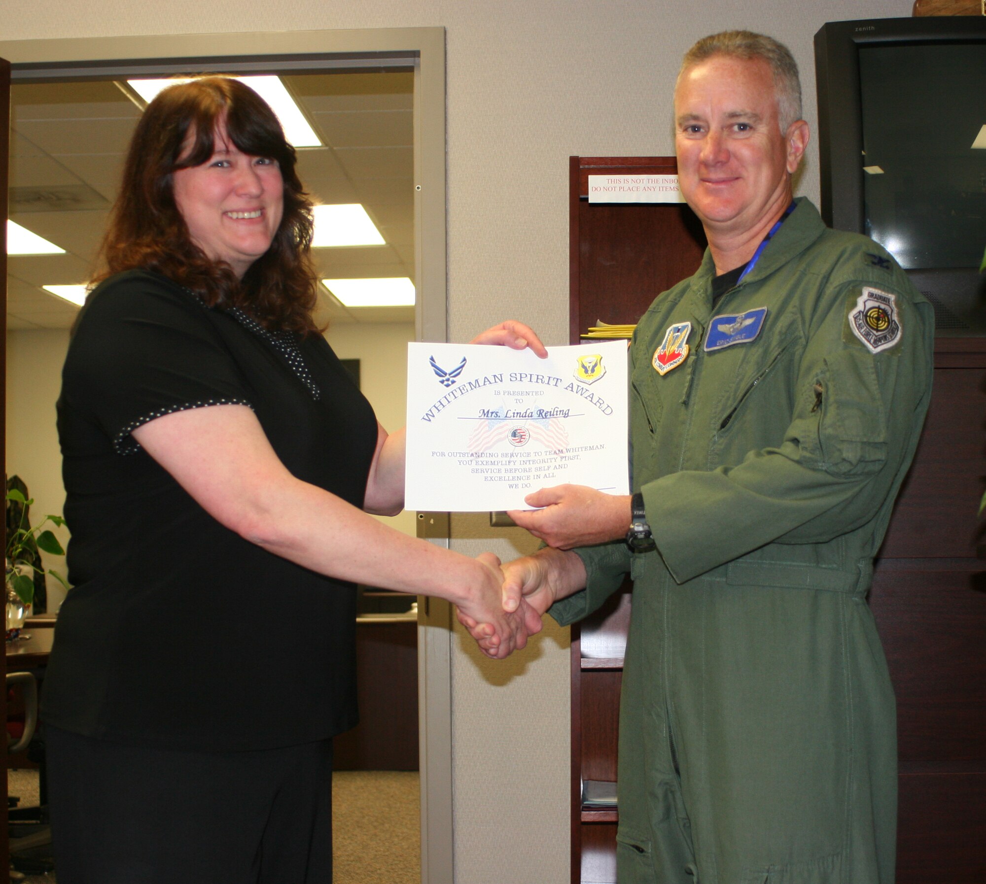 Linda Reiling, 509th Maintenance Group, receives the Whiteman Spirit Award from Col. Eric Single, 509th Bomb Wing vice commander, June 18. (U.S. Air Force photo/ Staff Sgt. Rob Hazelett)