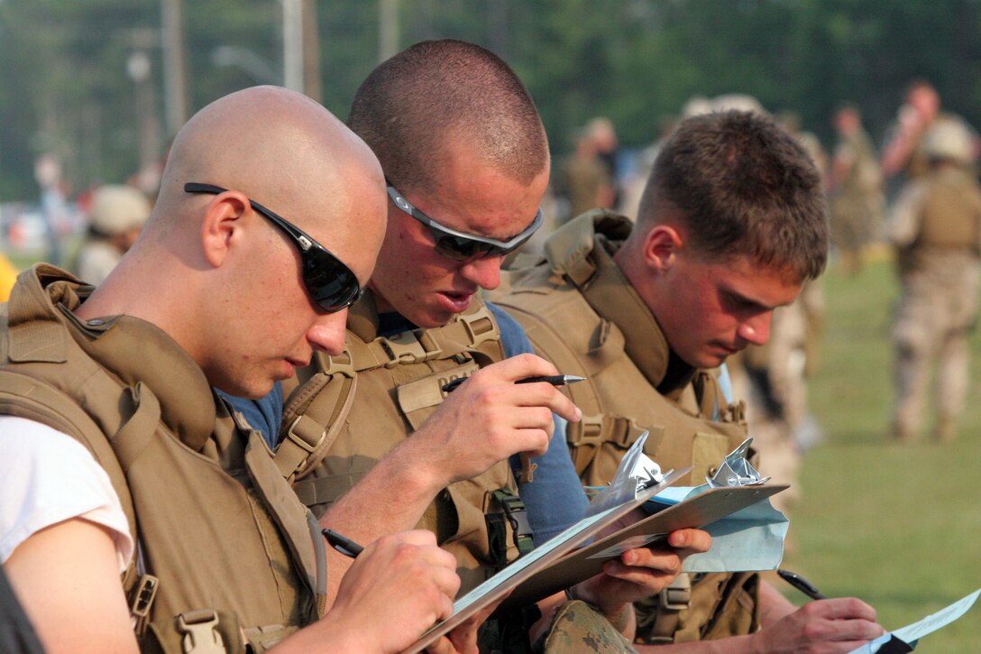 American evacuees from the "war-torn" notional country of Amberland fill out paper work from one of the five checkpoints set up by the Marines of the 22nd Marine Expeditionary Unit during a simulated non-combatant evacuation training exercise held June 22, 2007. The training exercise was one of the requirements the Marines and sailors of the 22nd MEU were required to complete during this portion of their pre-deployment training. (Official Marine Corps photo by Sgt. Ezekiel R. Kitandwe)::n::
