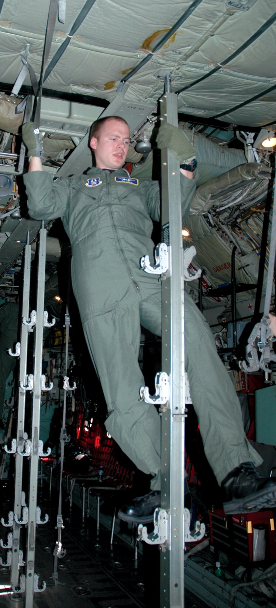 Capt. Jon Foss, an Air Force Reserve flight nurse with the 446th Airlift Wing, climbs a litter stanchion on a C-130 to begin breaking it down.  Captain Foss is one of five Airmen assigned to the 446th Aeromedical Evacuation Squadron who will be competing at Air Mobility Command's Rodeo competition July 21-28 at McChord Air Force Base, Wash.  (U.S. Air Force photo/Sandra Pishner)