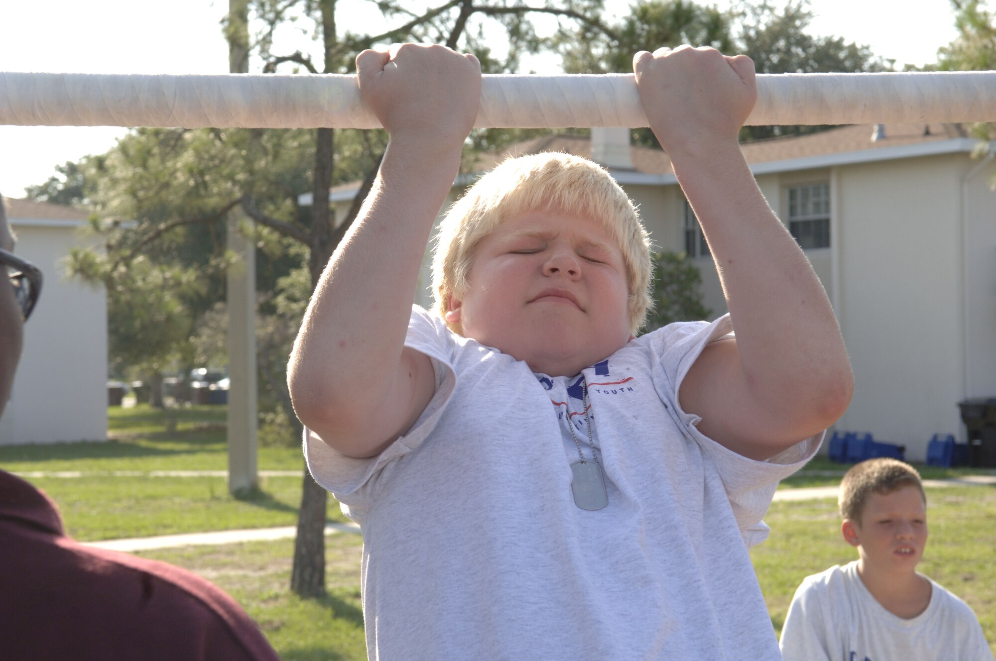 A Drug Education for Youth participant does a pullup during the week long training session. The session is held each year to educate youth on the dangers of drugs. The program covered drug identification and dealing with peer preasure, as well as a cardboard boat regata, held at the base beach June 13. 