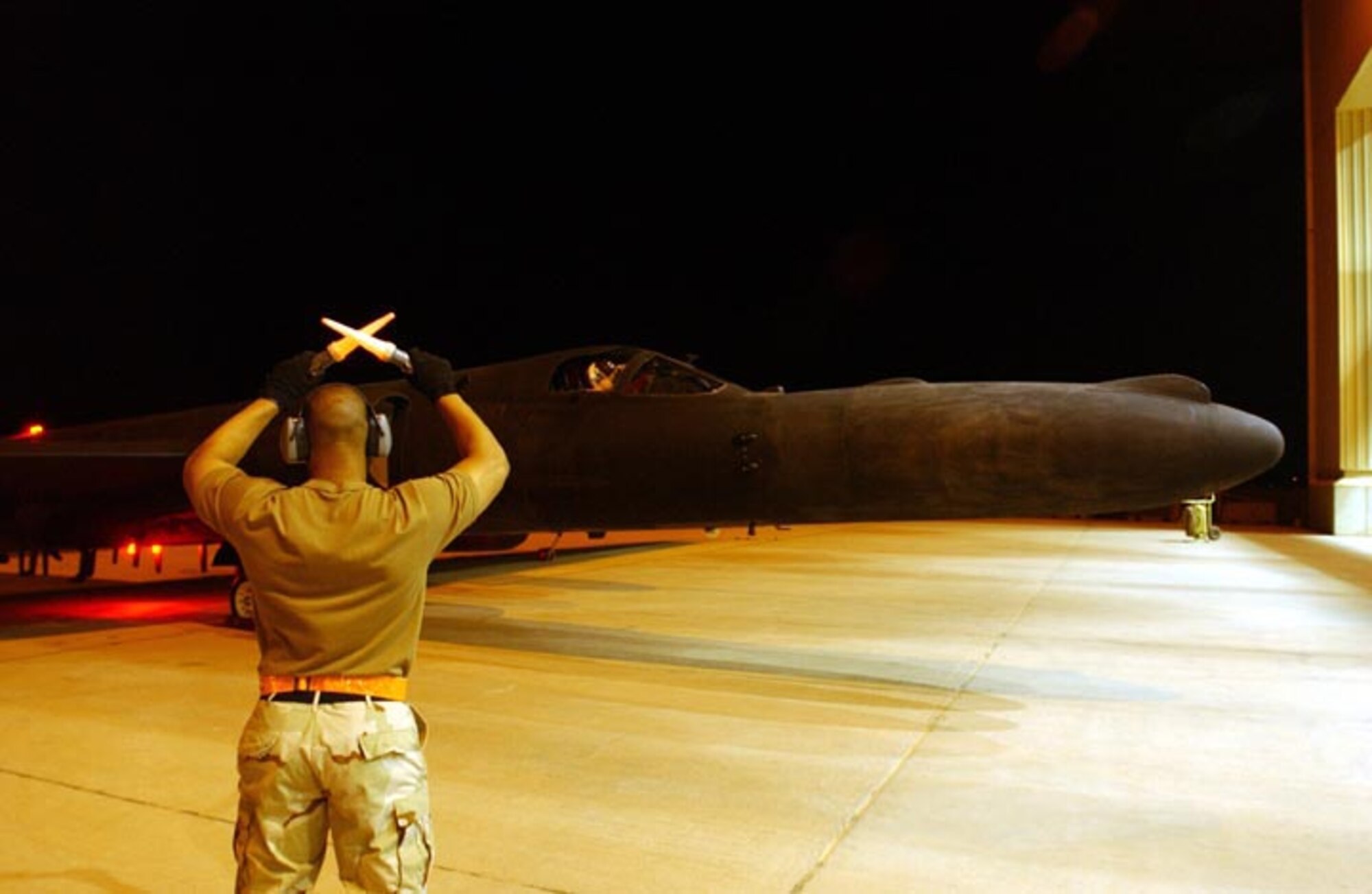 Master Sgt. Lamont Pollock, Crew Chief, 9th Aircraft Maintenance Squadron, 363rd Expeditionary Aircraft Maintenance Squadron, marshals a U-2R Dragon Lady aircraft in to position following a reconnaissance mission at a forward deployed location in Southwest Asia, during Operation IRAQI FREEDOM. (U.S. Air Force photo/Staff Sgt. Matthew Hannen) 