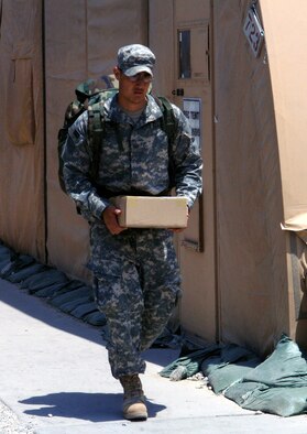 Senior Airman Bradley Luu, 455th Expeditionary Communications Squadron, picks up a package from the post office after returning from a forward operating base in Afghanistan. Airman Luu travels to different forward operating bases in theater to assist with the transisition to a more efficient communications system which allows the A-10 pilots to communicate with Army ground forces for direct ground support. Airman Luu is one of many Airmen wearing the Army Combat Uniform when working alongside his Army counterparts in theater. Airman Luu is deployed from the 27th Communications Squadron, Cannon Air Force Base, N.M. (photo by Staff Sgt. Craig Seals)