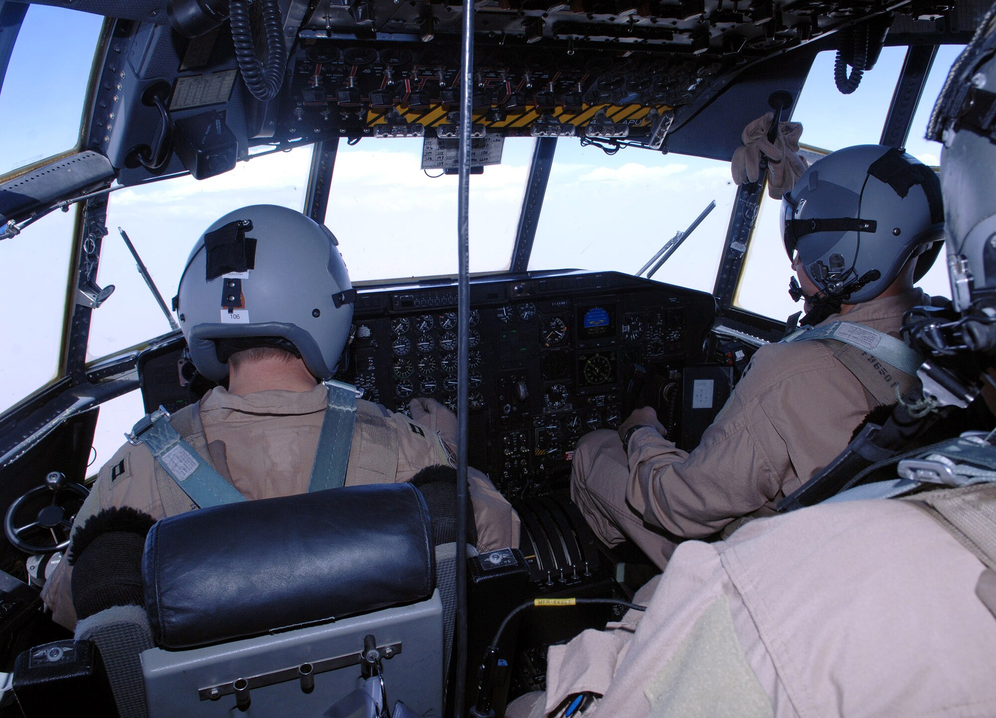 Capt. Scott Simon (left), 774th Expeditionary Airlift Squadron C-130 pilot, and Capt. John Malley (right), 774th EAS co-pilot, tend to the controls of their C-130 during an aeromedical evacuation and airlift mission from Bagram Airfield, Afghanistan. Capts. Simon and Malley are deployed from Wyoming's Air National Guard, Cheyenne, Wyo. (photo by Staff Sgt. Craig Seals)