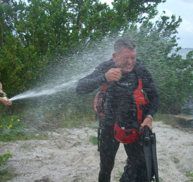 PATRICK AIR FORCE BASE - Air Force Reservist and pararescueman, Chief Master Sgt. Jeff Curl, made his final jump as a PJ with the 920th Rescue Wing June 21.  Fellow 308th Rescue Squadron PJs leapt with him and then sprayed the 52-year-old with champagne as he stepped ashore after the 3,500-foot jump from an HC-130P/N into the Banana River.  Out of his 28 years in the service, he spent the last 15 here.  He said one of his most gratifying missions was when he and his unit rescued 1,043 people from the aftermath of Hurricane Katrina.  He said his helicopter rescued 199 people in two days.